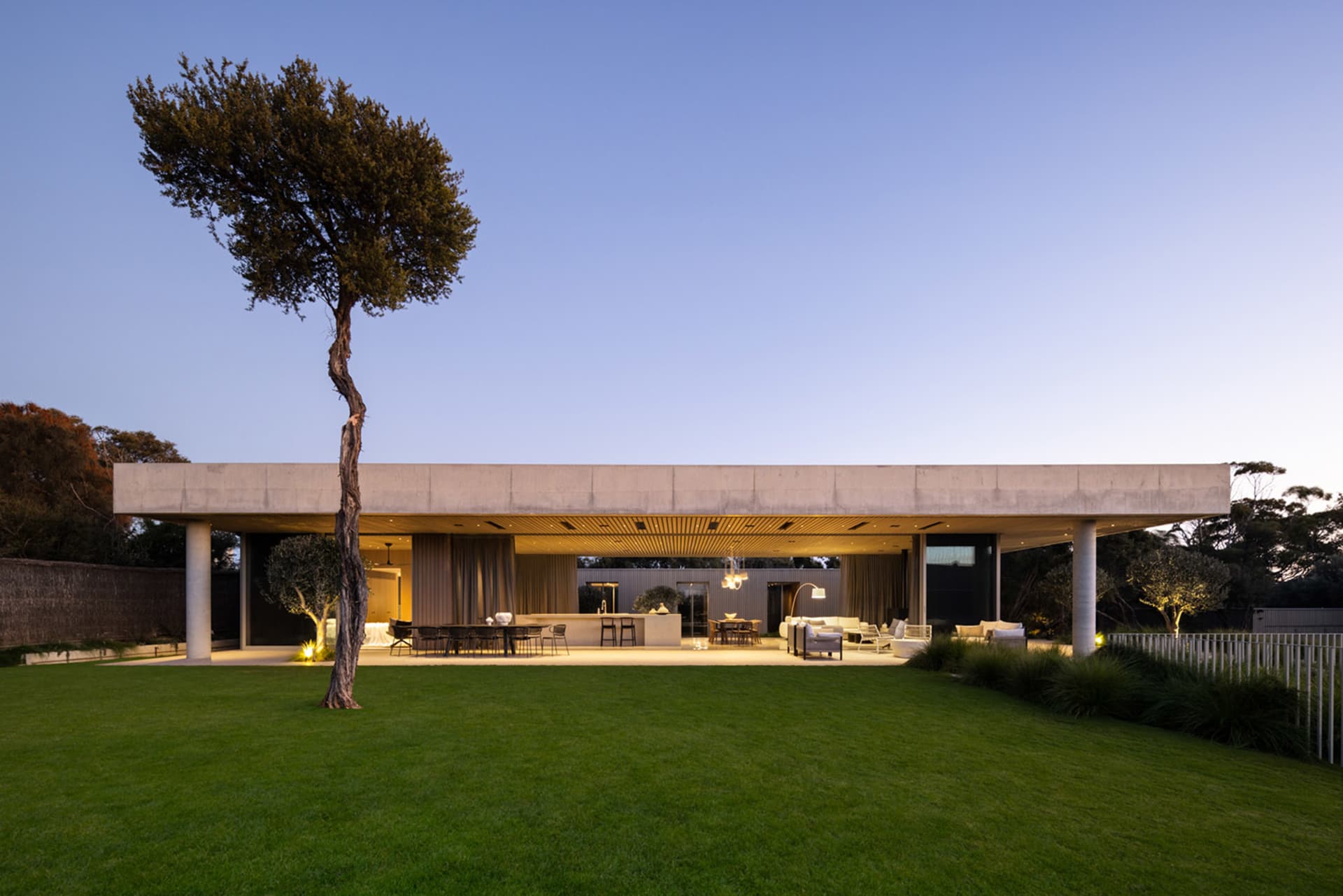 A modern living space with a concrete structure and glass elements.