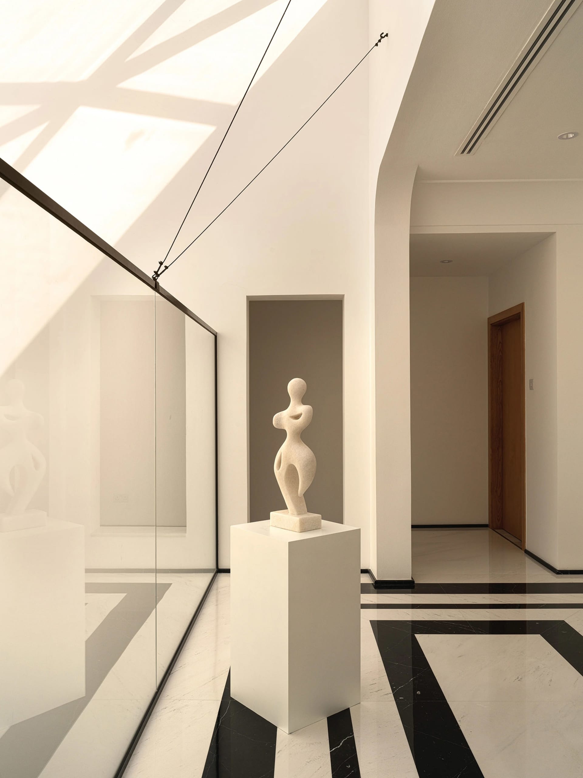 Modern, minimalist lobby with marble flooring and glass walls.