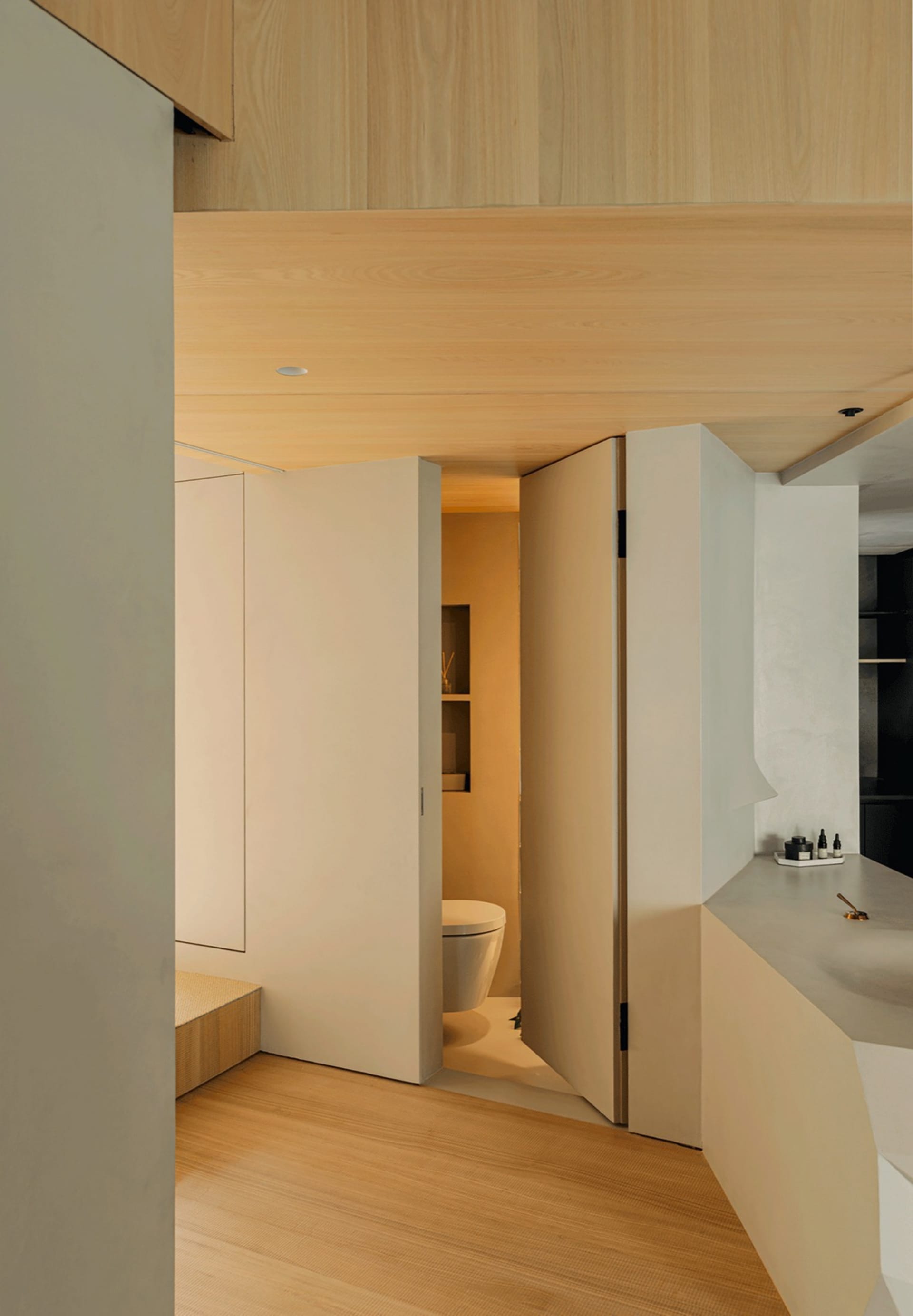 Modern bathroom featuring wooden panels and a concrete surface.