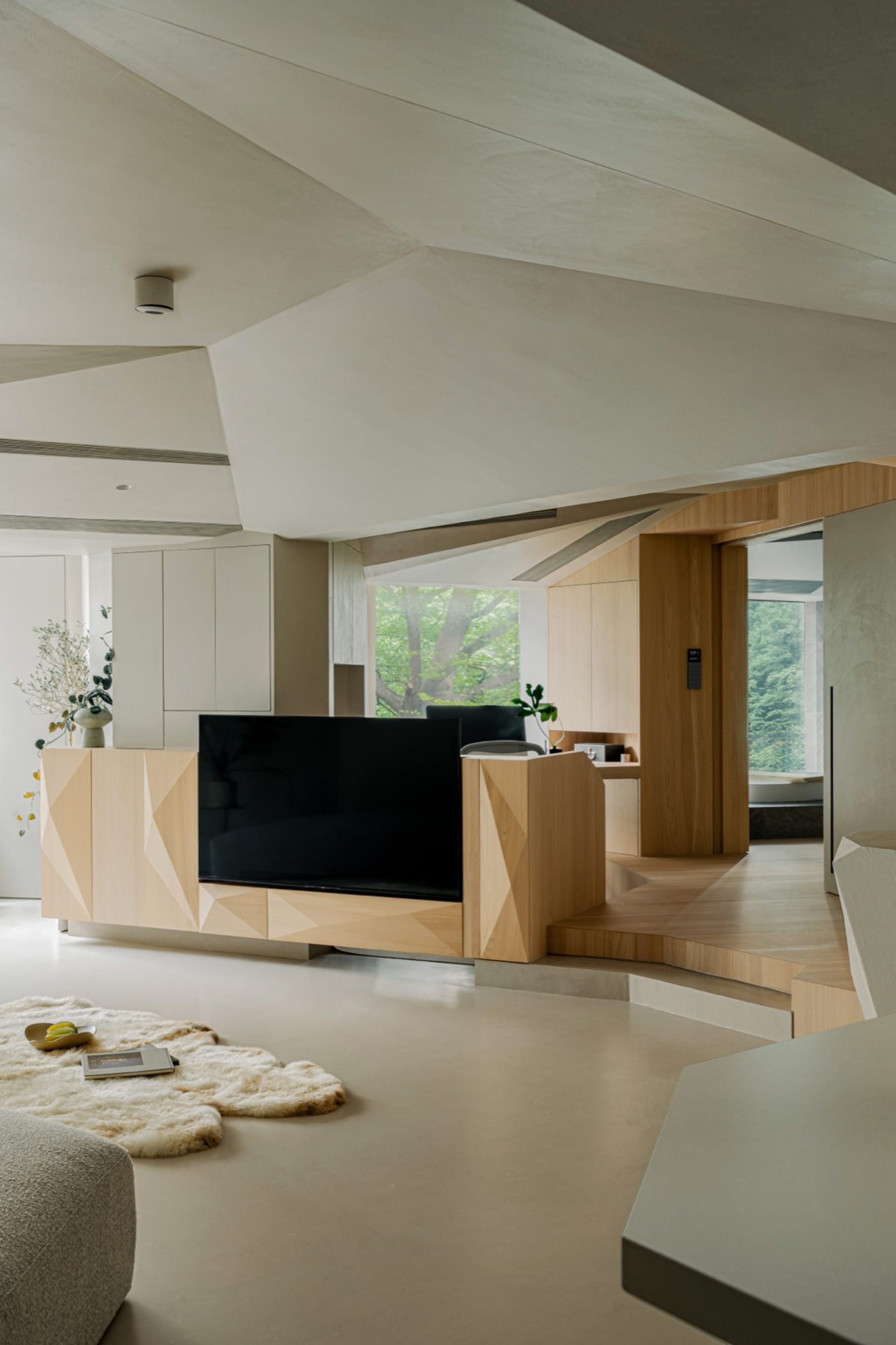 A modern minimalist living room featuring natural wood and concrete materials.