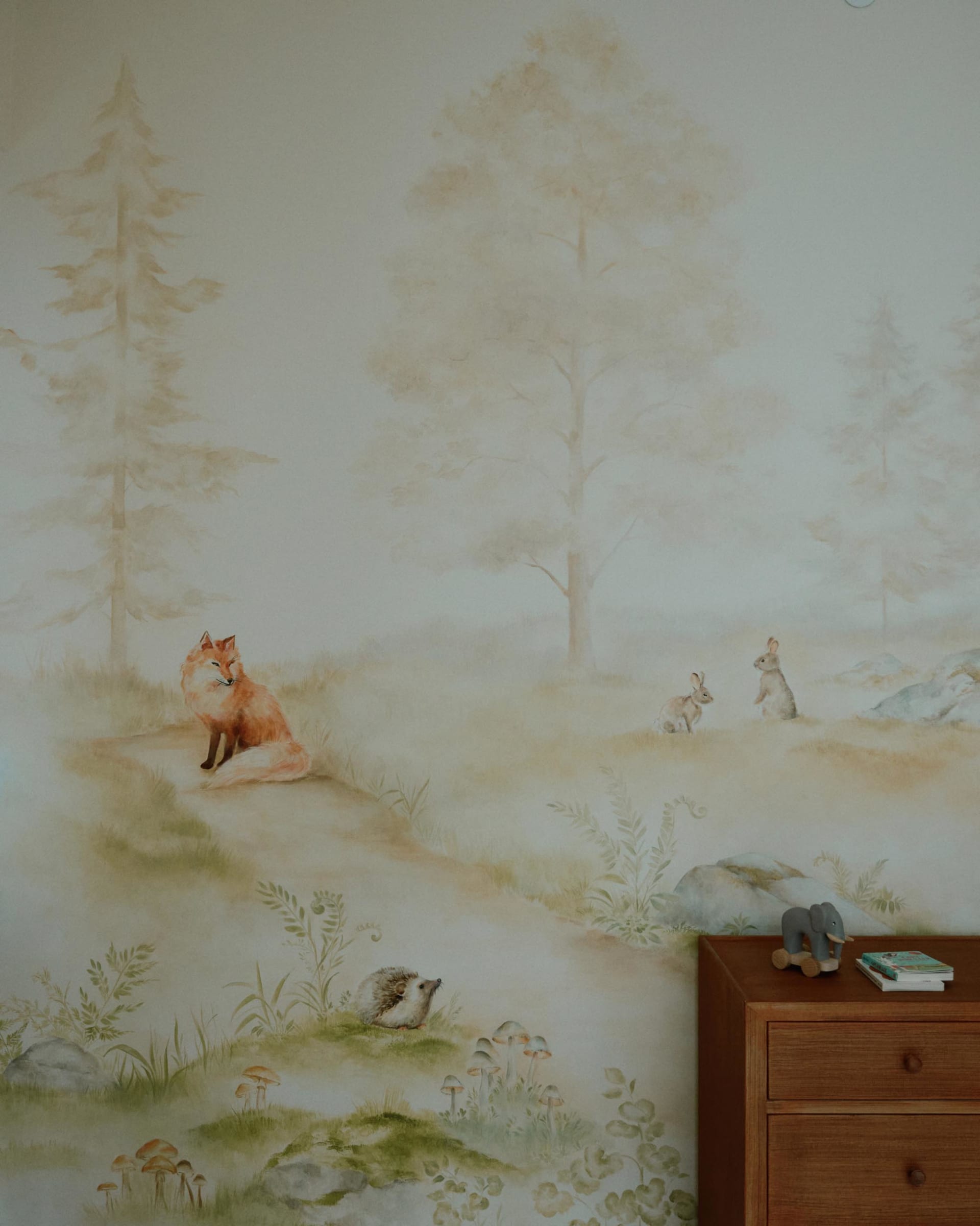 兒童房內的彩繪壁畫,描繪霧氣瀰漫的森林景象,包含動物與植物。