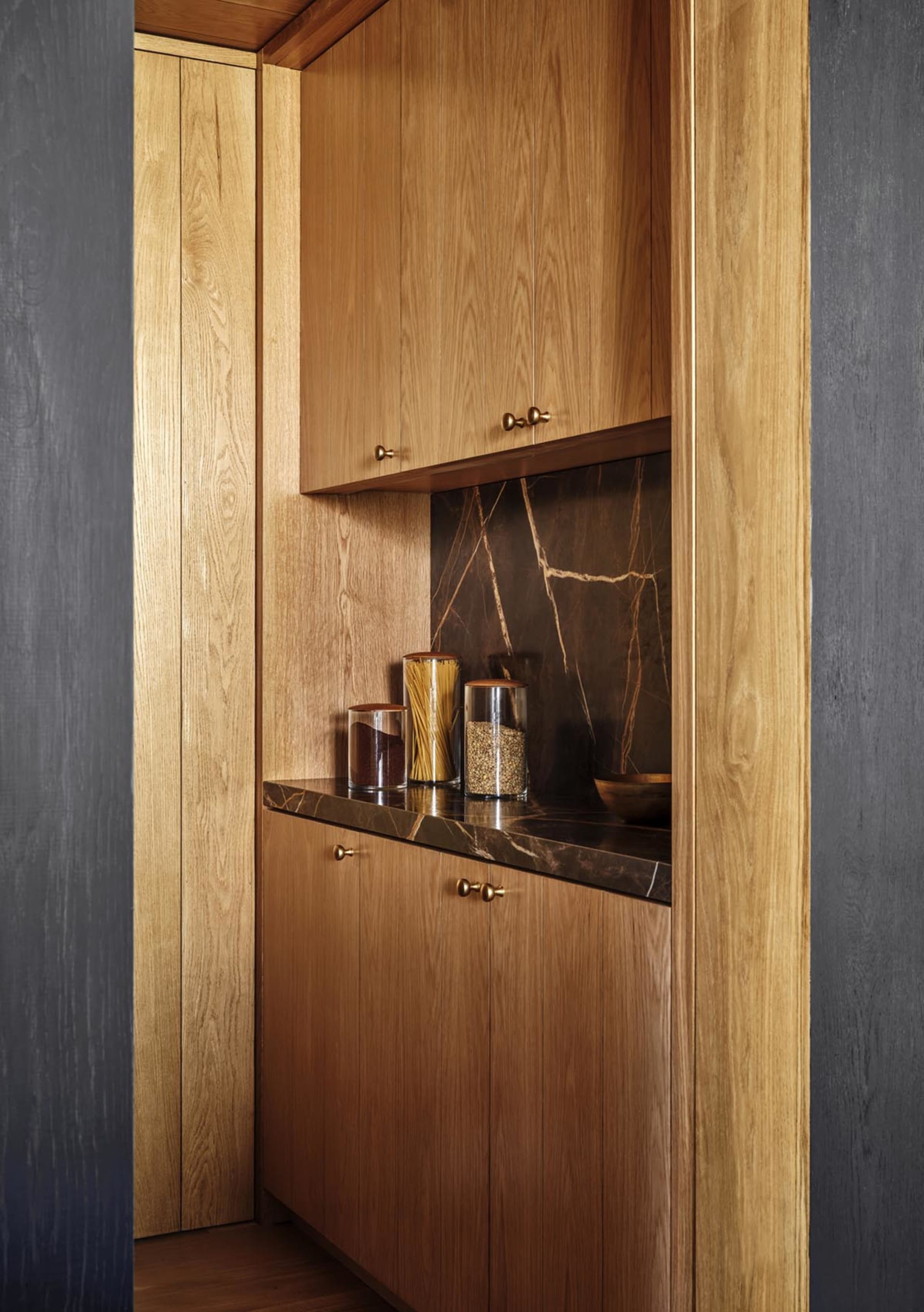 Modern kitchen featuring wooden cabinets with marble countertops