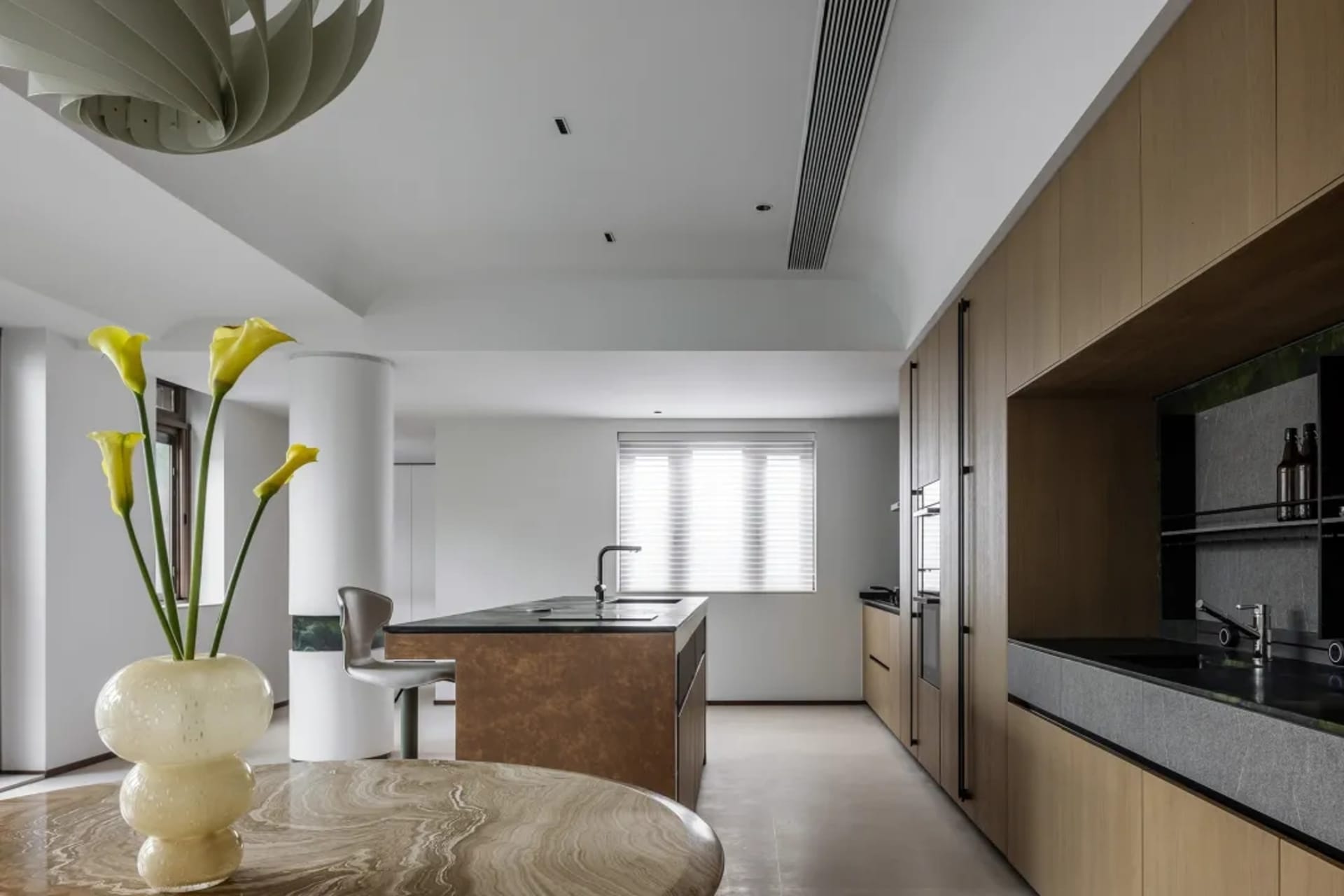 Modern residential kitchen featuring a marble countertop and wooden cabinets.