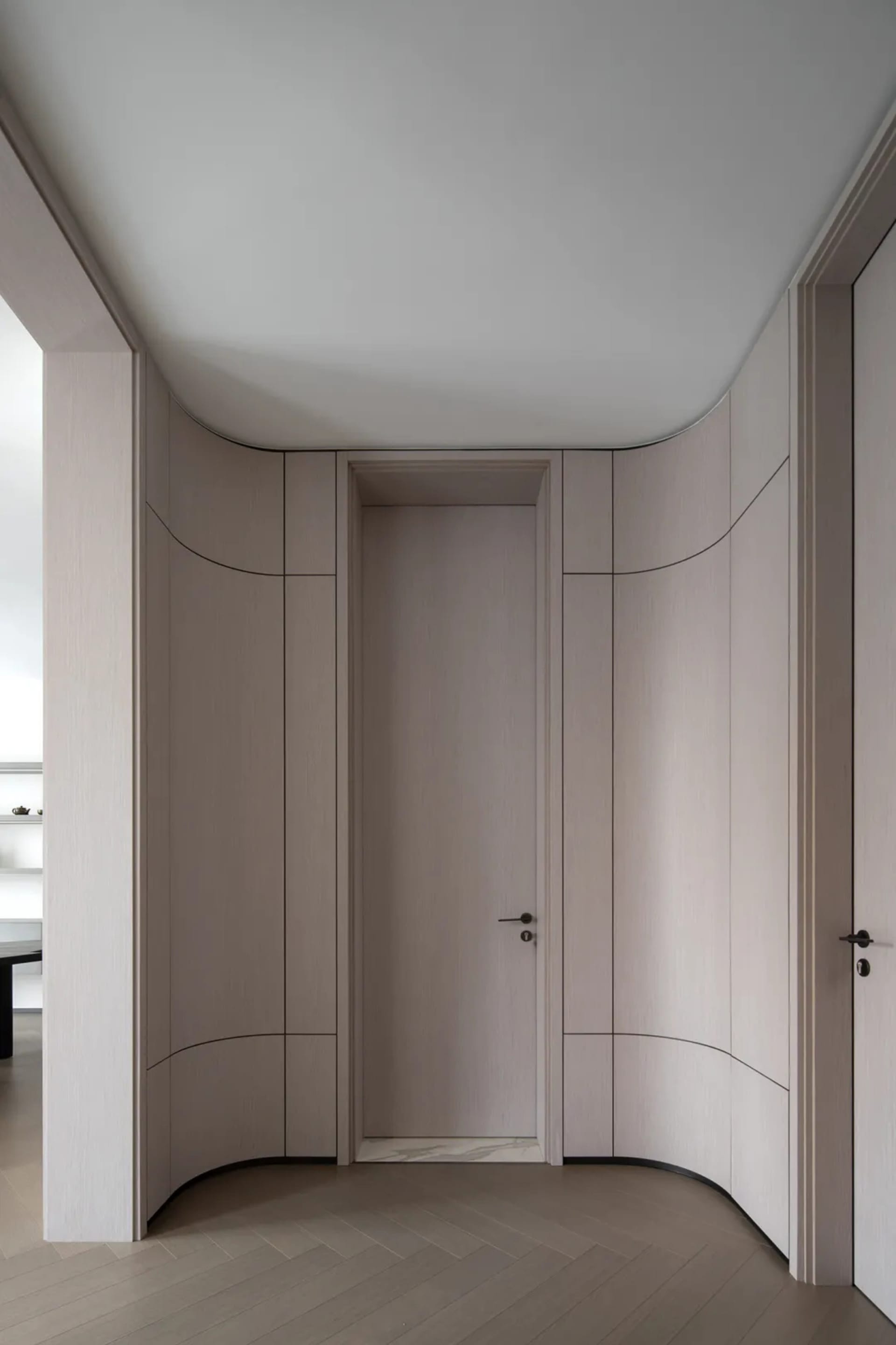 Modern entry way with curved panel closet doors and curved ceiling.