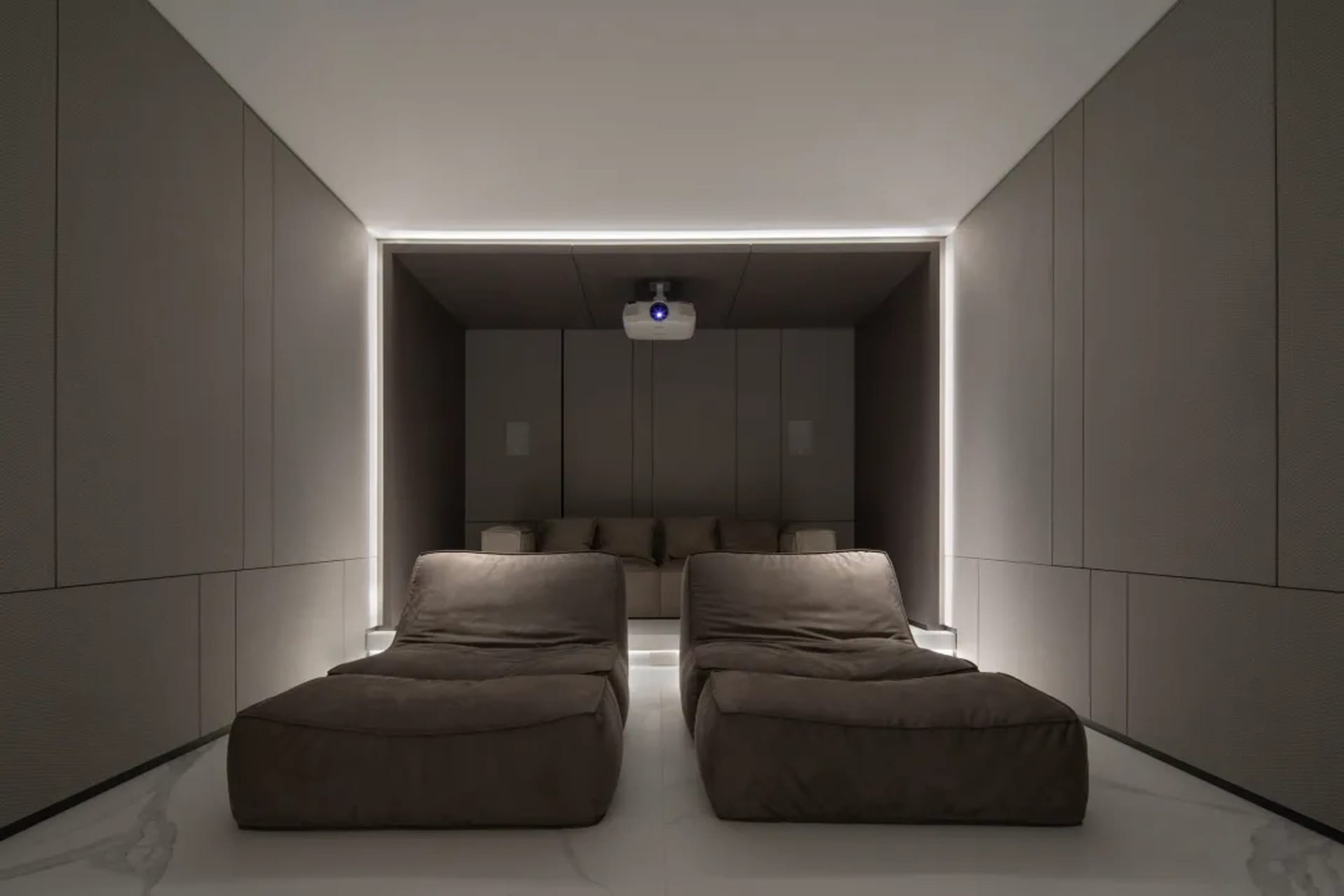 A modern home theater with fabric seats, featuring a minimalist design and ambient lighting.