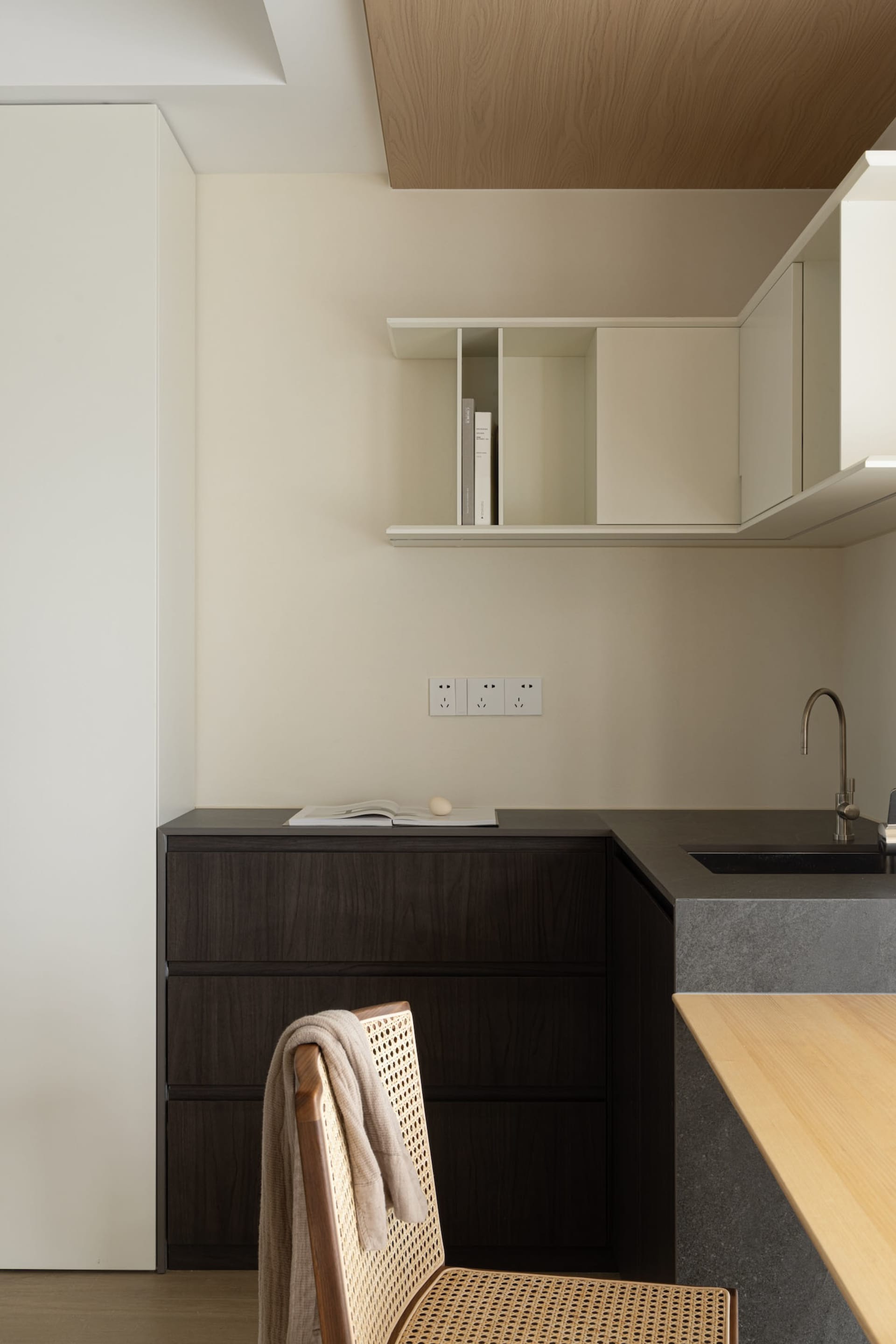 Minimalist kitchen featuring modern minimalism styled with dark wood cabinets and a concrete countertop.