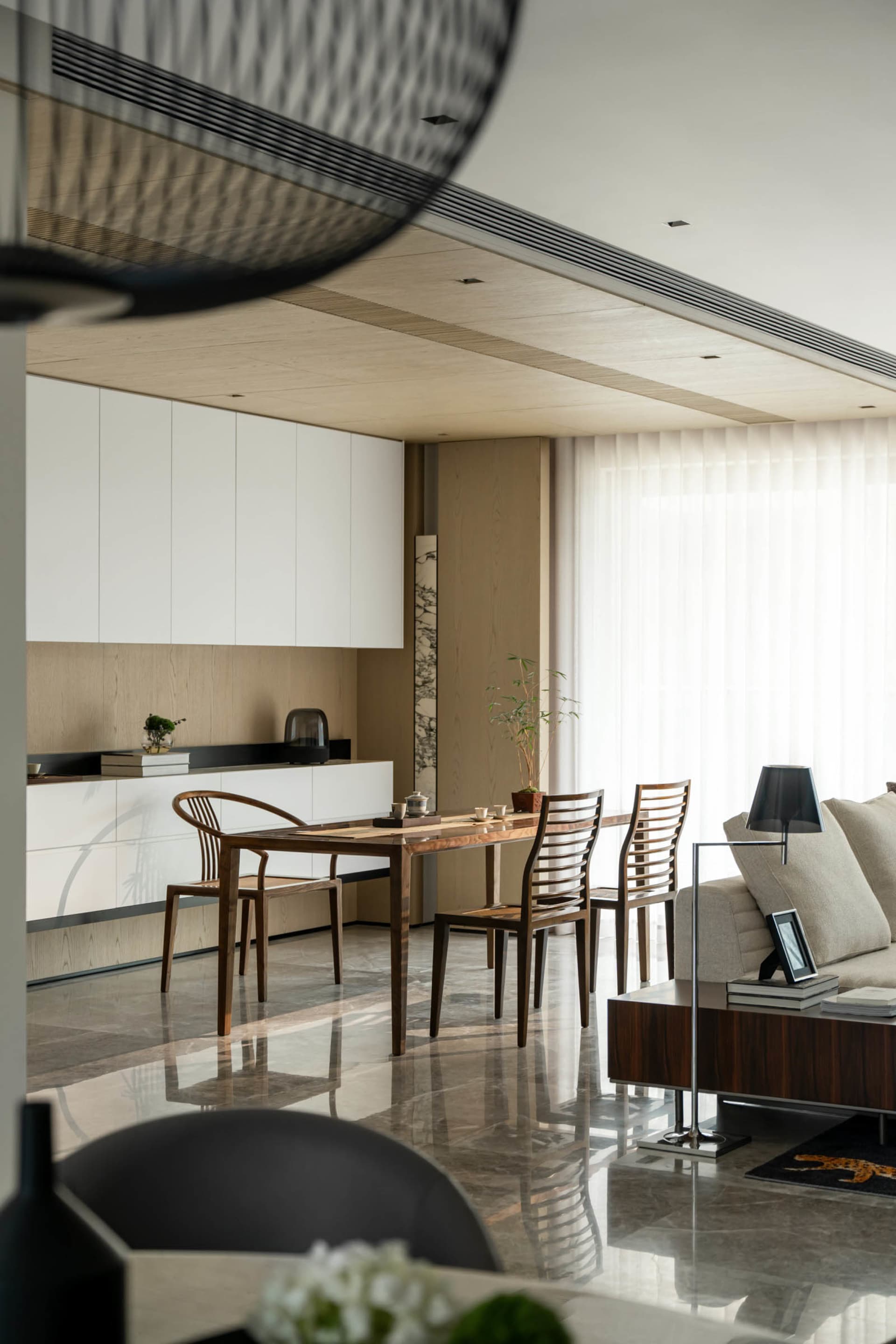A modern living and dining room featuring marble surfaces and contemporary furniture.