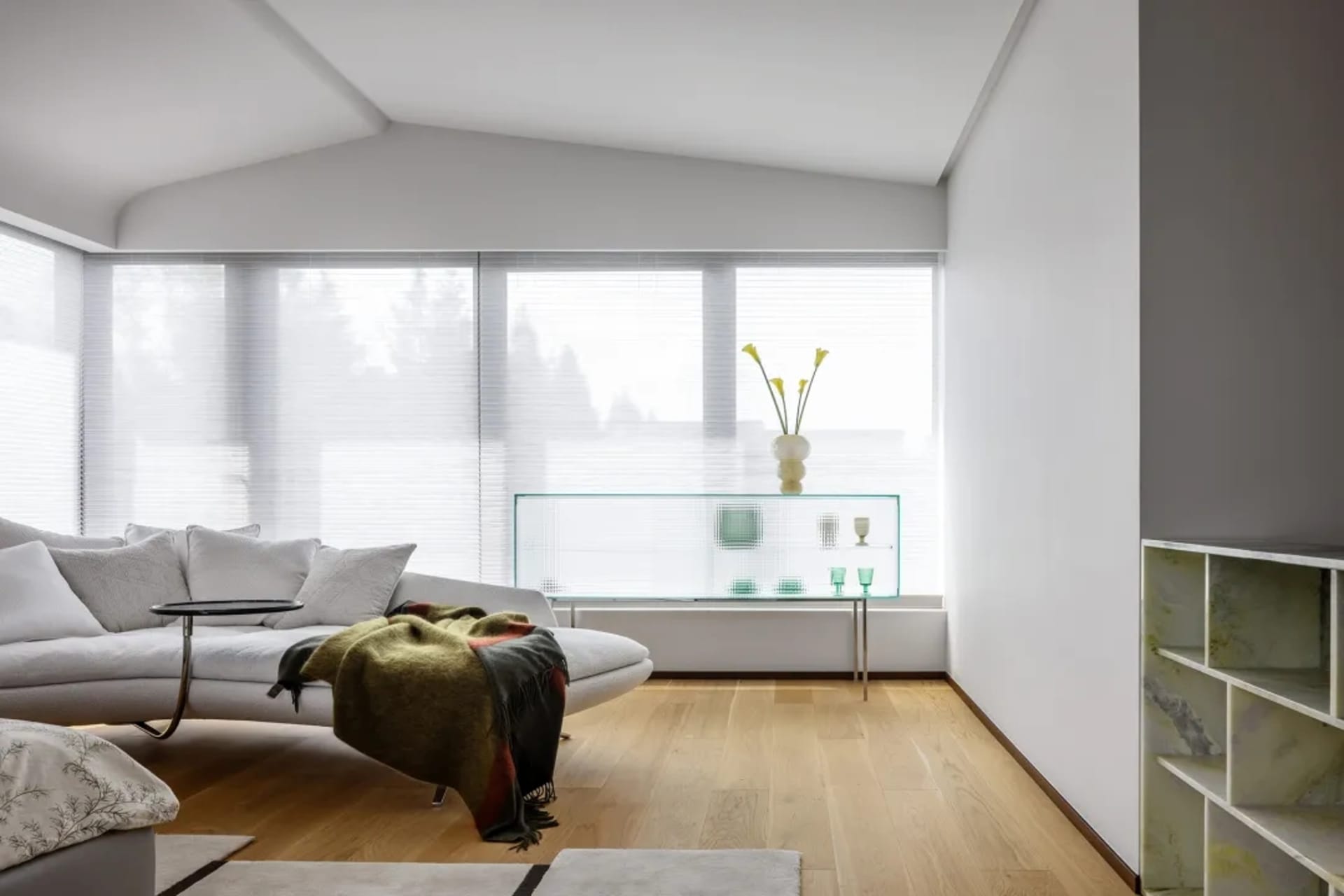 Modern living room featuring glass windows, aluminum accents, wooden flooring, and plush furnishings
