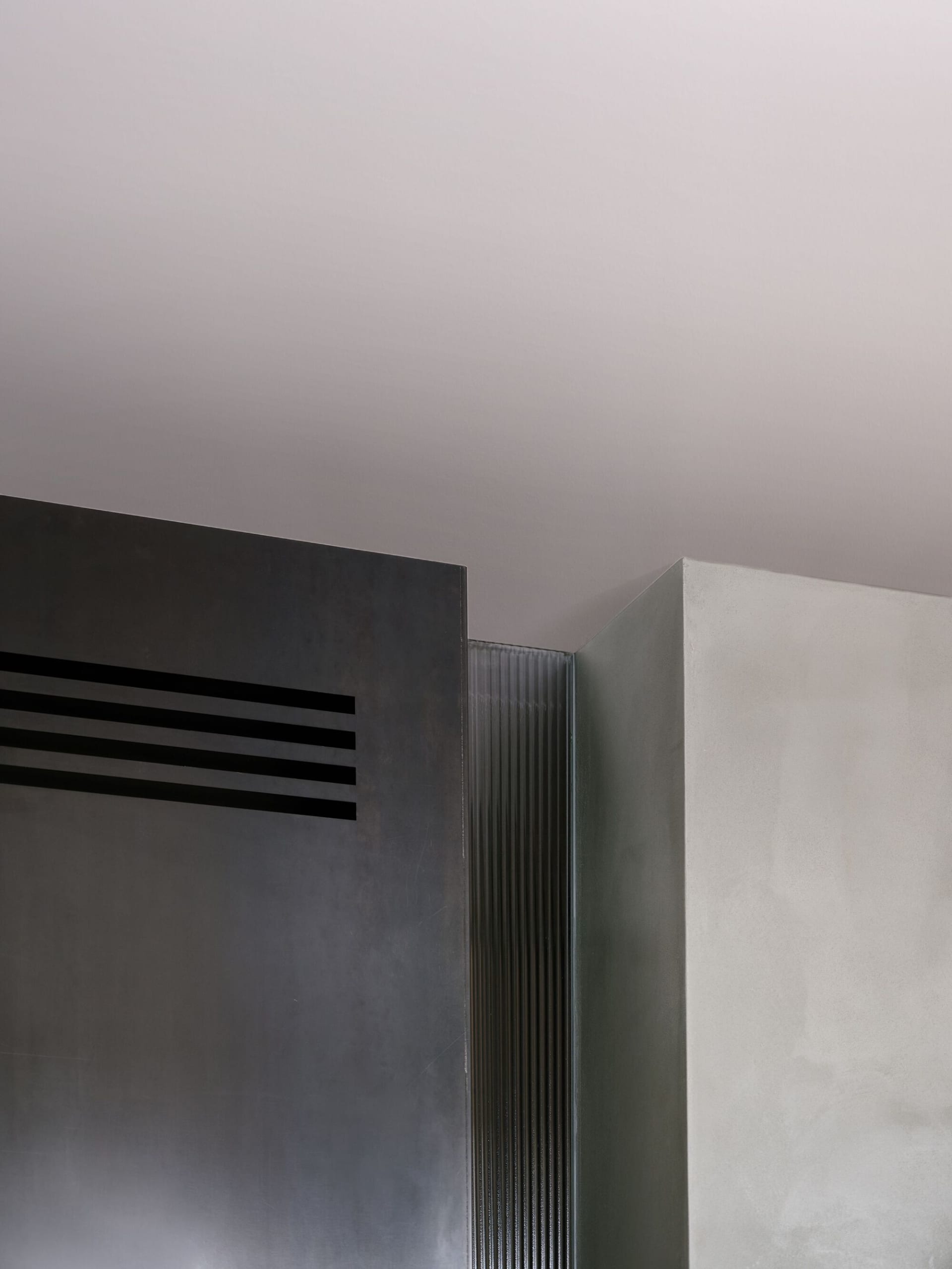 A modern architectural detail featuring a metallic metal cantilever beam supported by a concrete floor structure.
