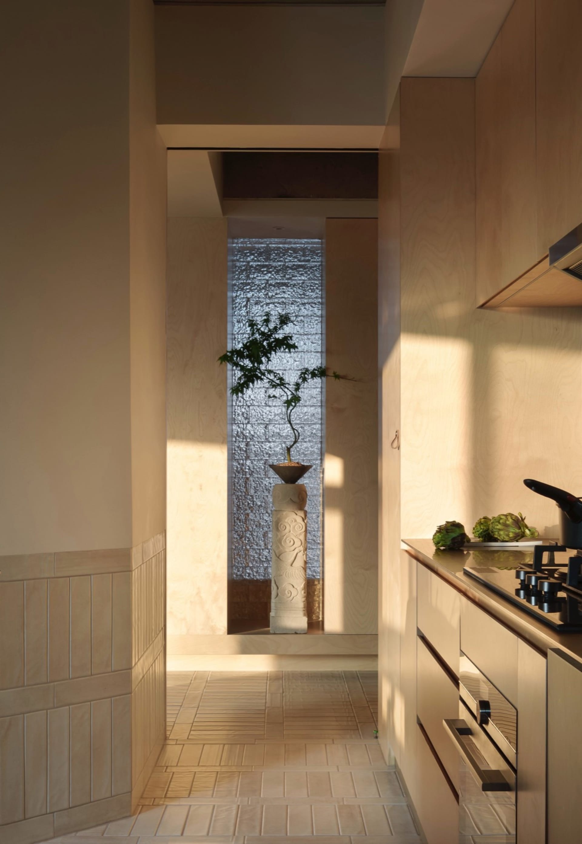 A minimalist kitchen with wooden cabinets and porcelain countertops.