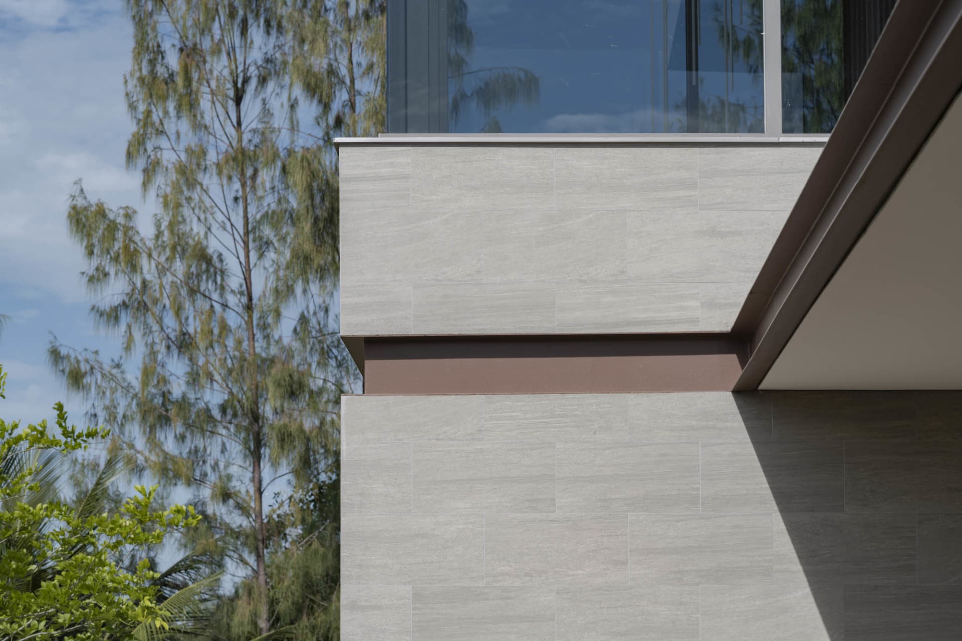 Modern home exterior featuring a tile wall and large windows.