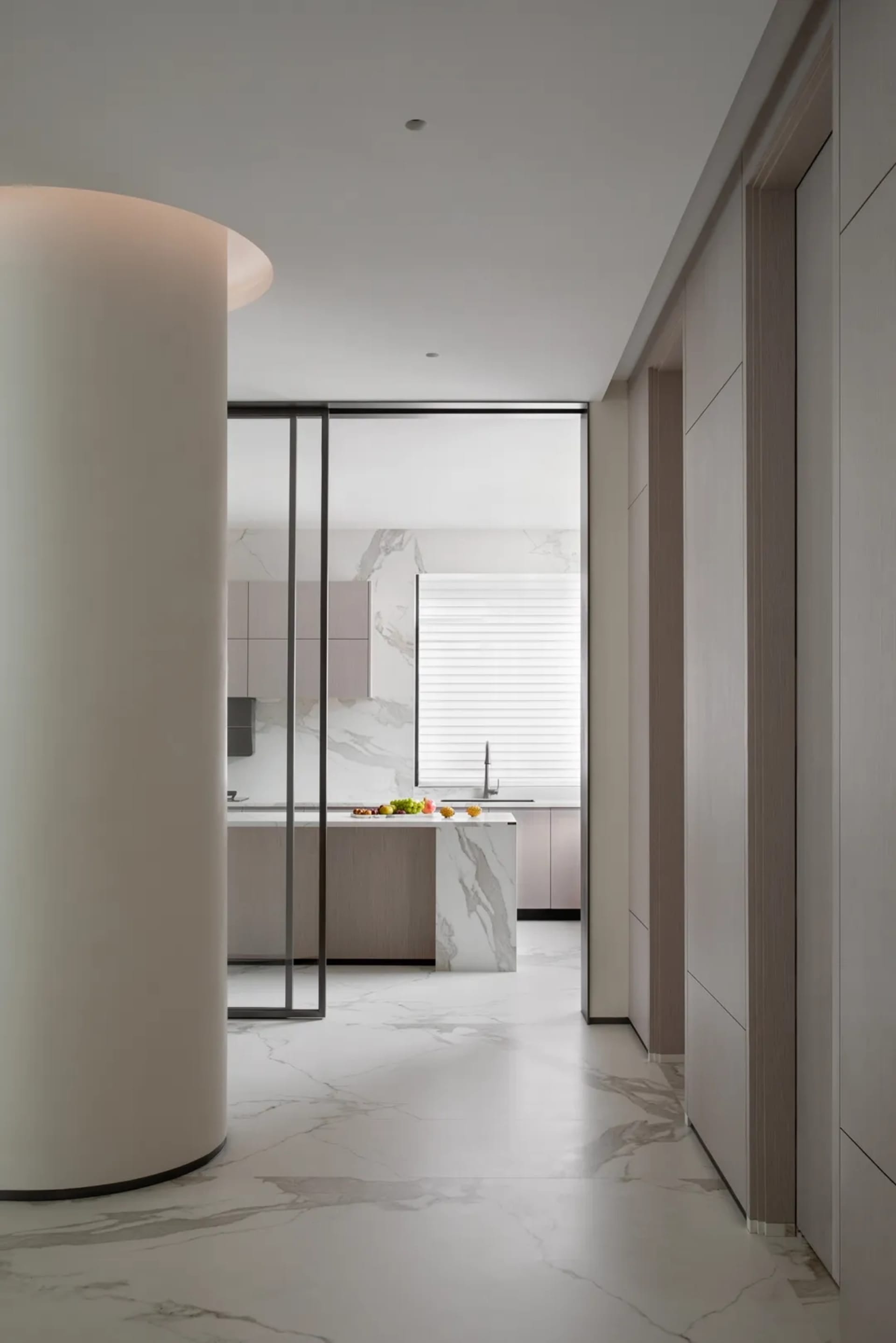Modern kitchen interior featuring marble countertops and a large island.