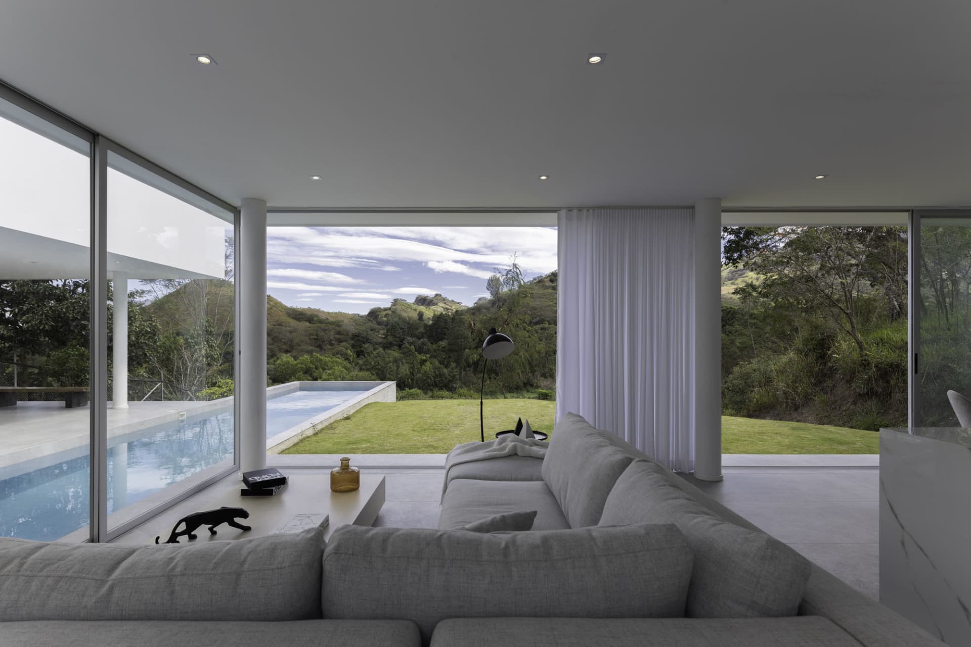 Modern white-painted interior with furniture and a view of a spa pool.