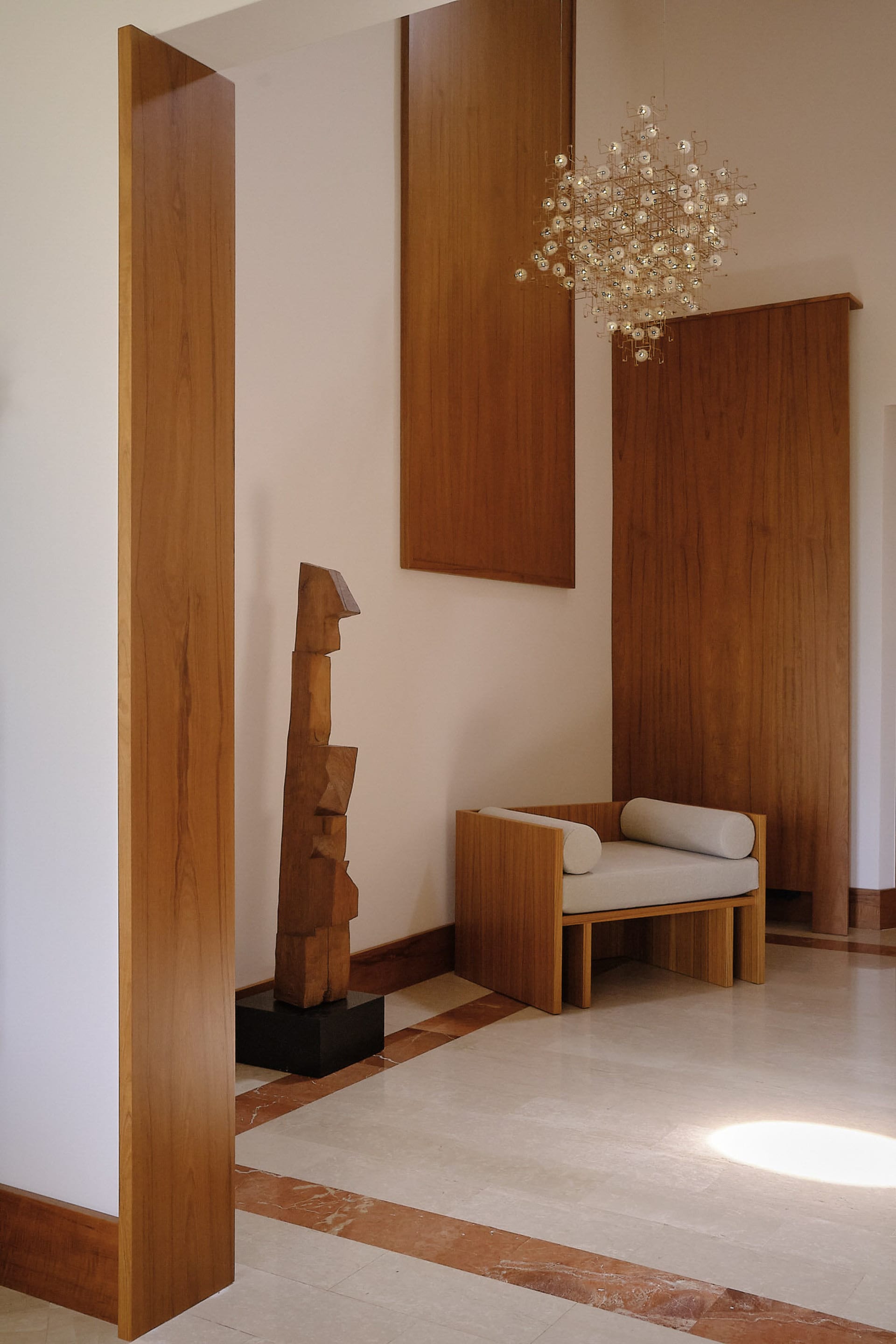 Modern living room featuring wooden furniture and a wooden sculpture.