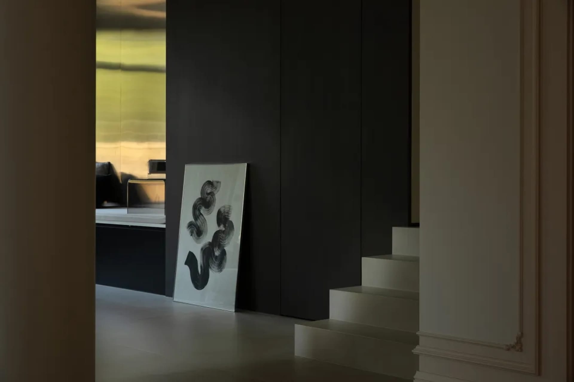 A modern living room with a metallic clad wall and abstract artwork in a minimalist style.