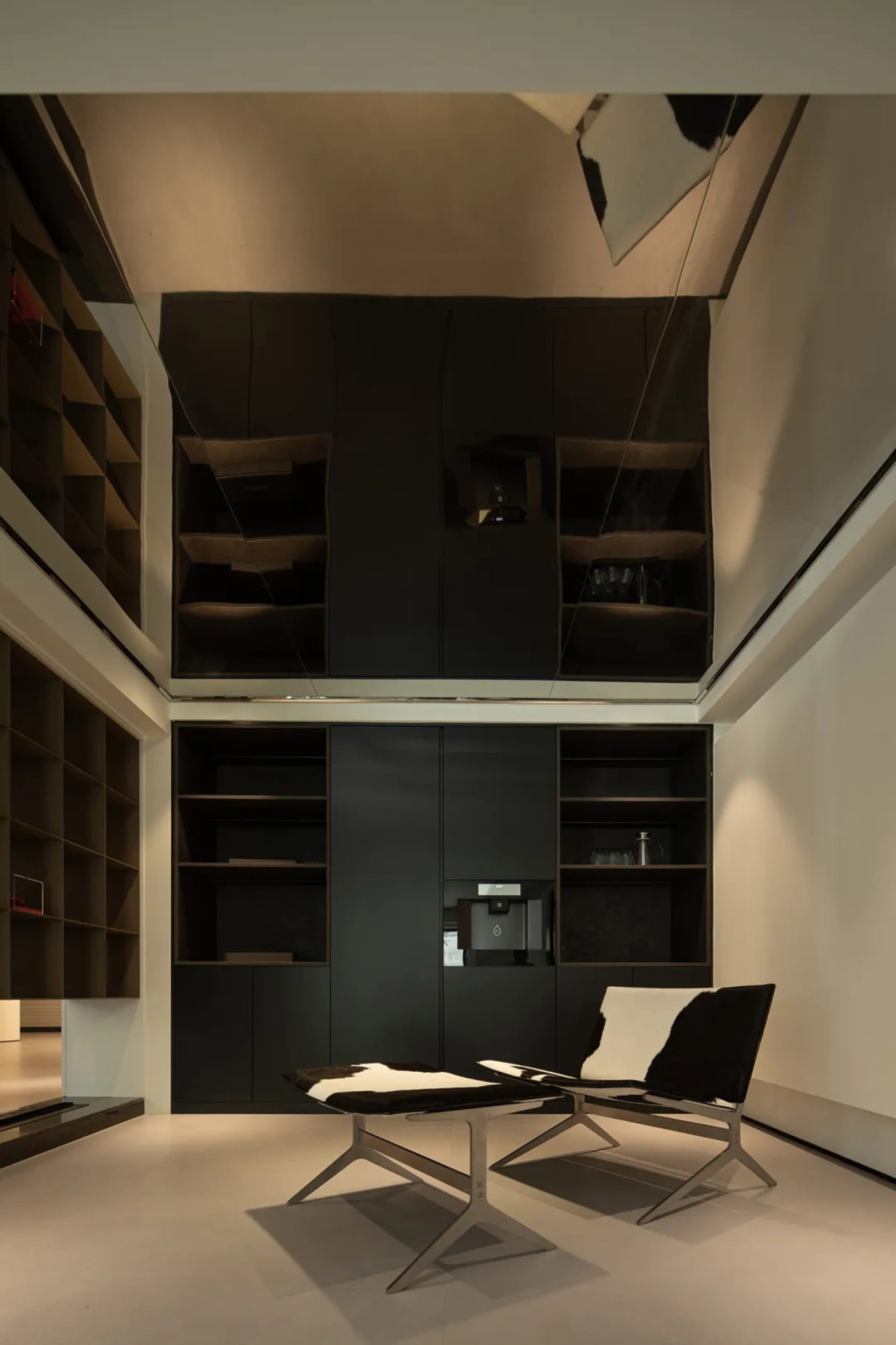 A modern office space featuring minimalist design and industrial aesthetics, with a focus on open shelving, black and grey ma