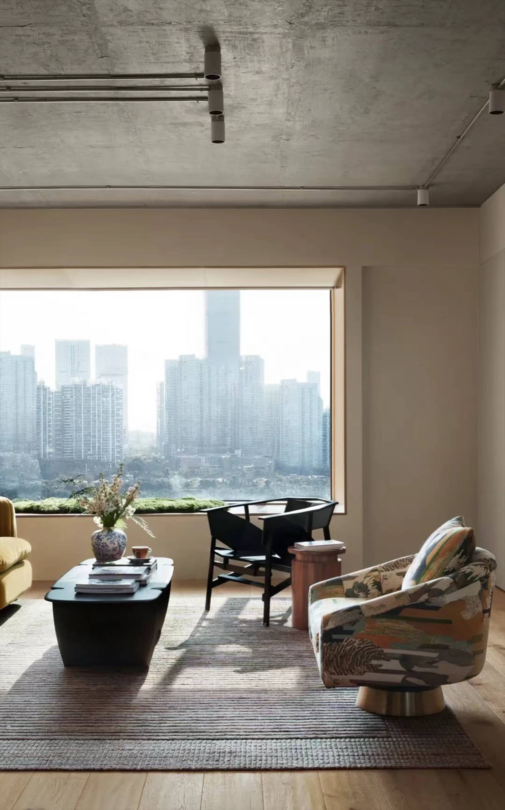 現代客廳，混凝土牆面搭配落地窗，窗外可見城市景觀。