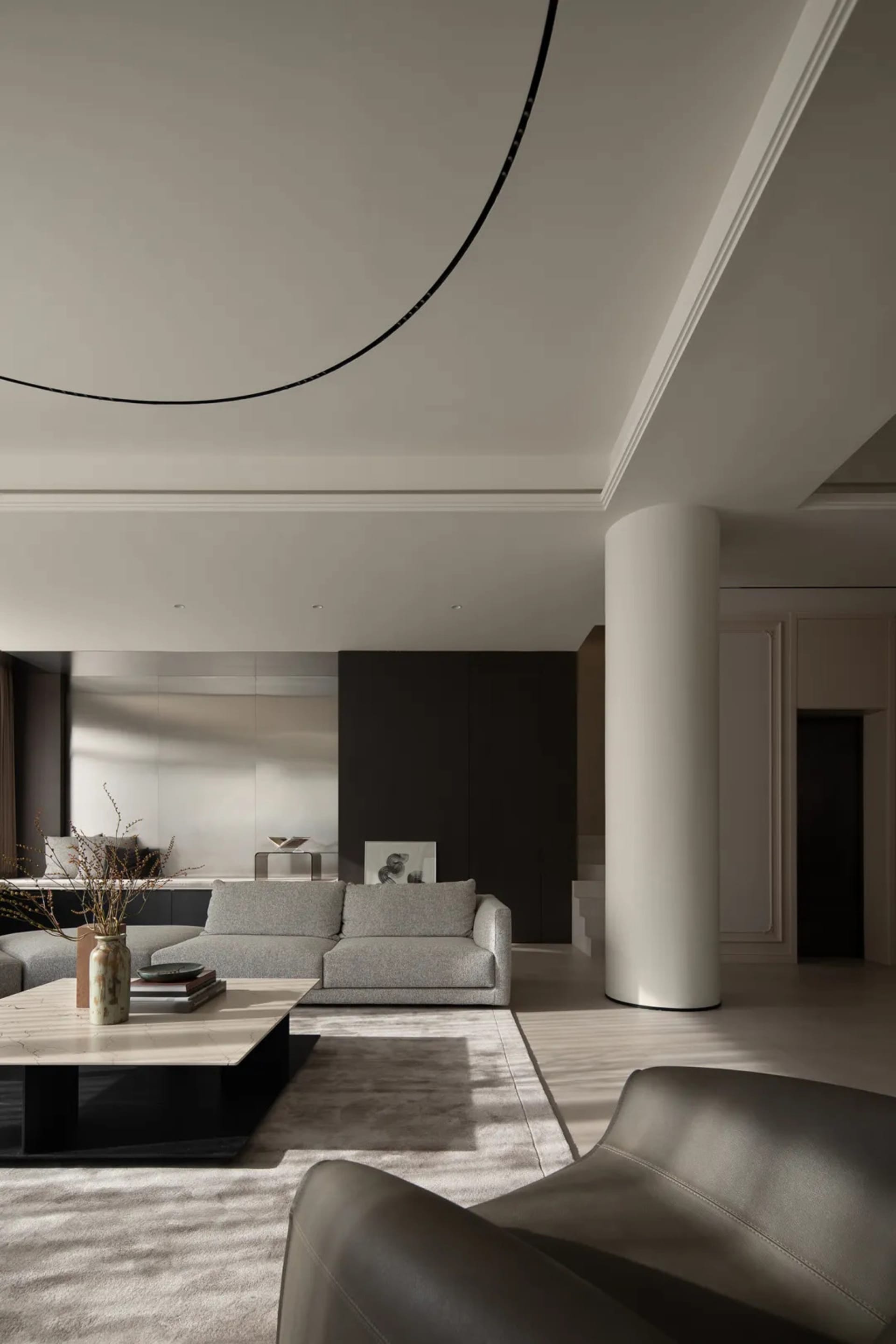 Modern living room featuring minimalist design with concrete walls, marble coffee table, and leather sofa.