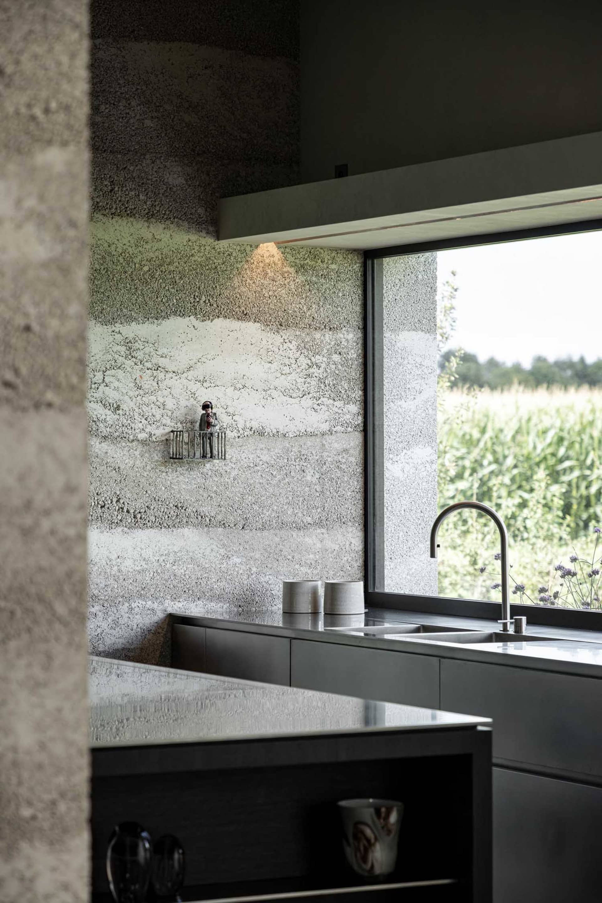 A modern kitchen featuring concrete walls and stainless steel appliances.