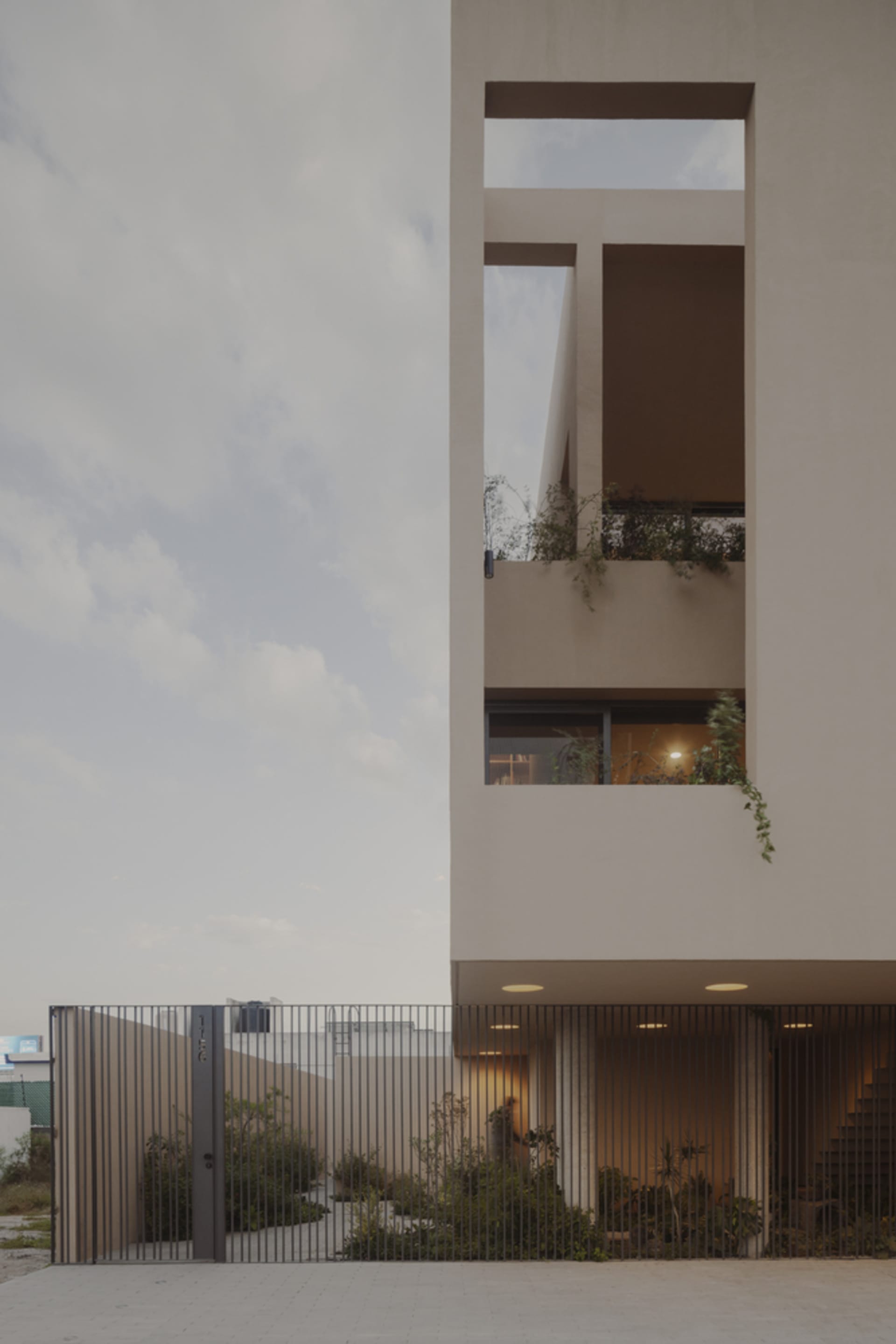 A modern residential living room with concrete walls and a large glass window.
