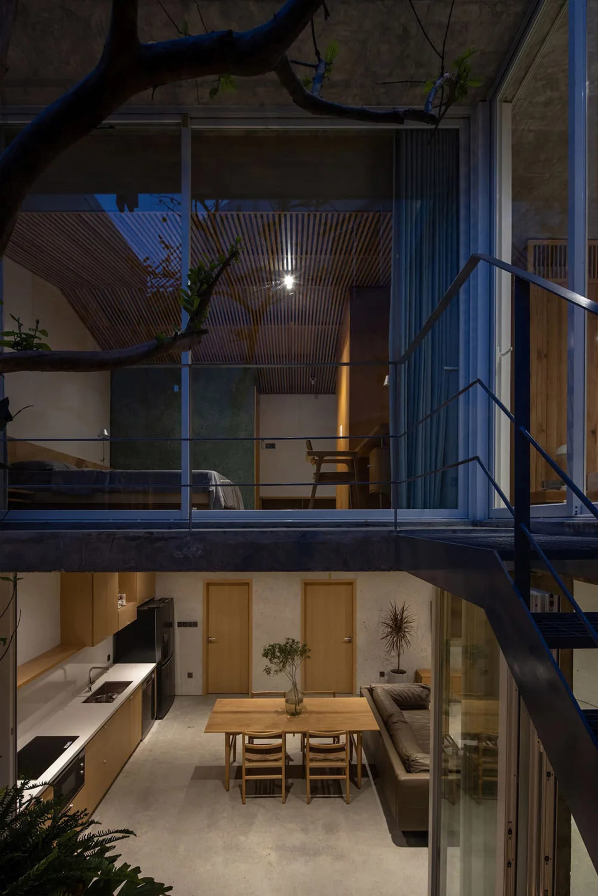 Modern residential interior featuring glass walls and concrete floors.