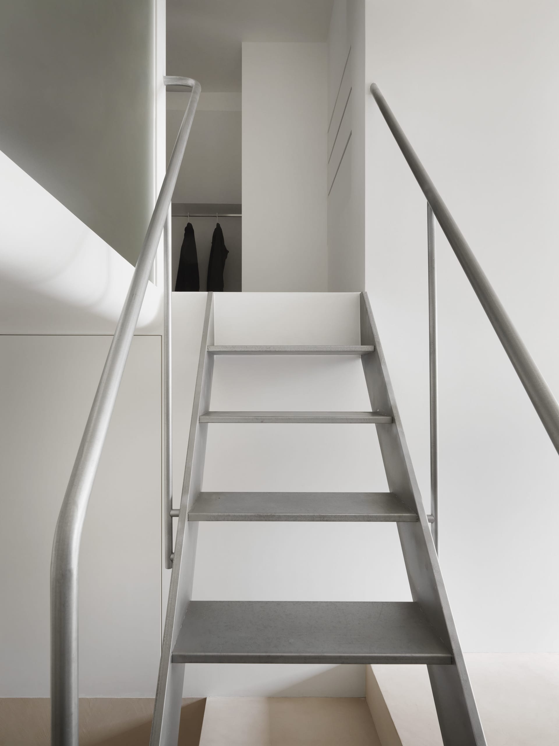 Concrete stairs with metal handrails in a minimalist interior