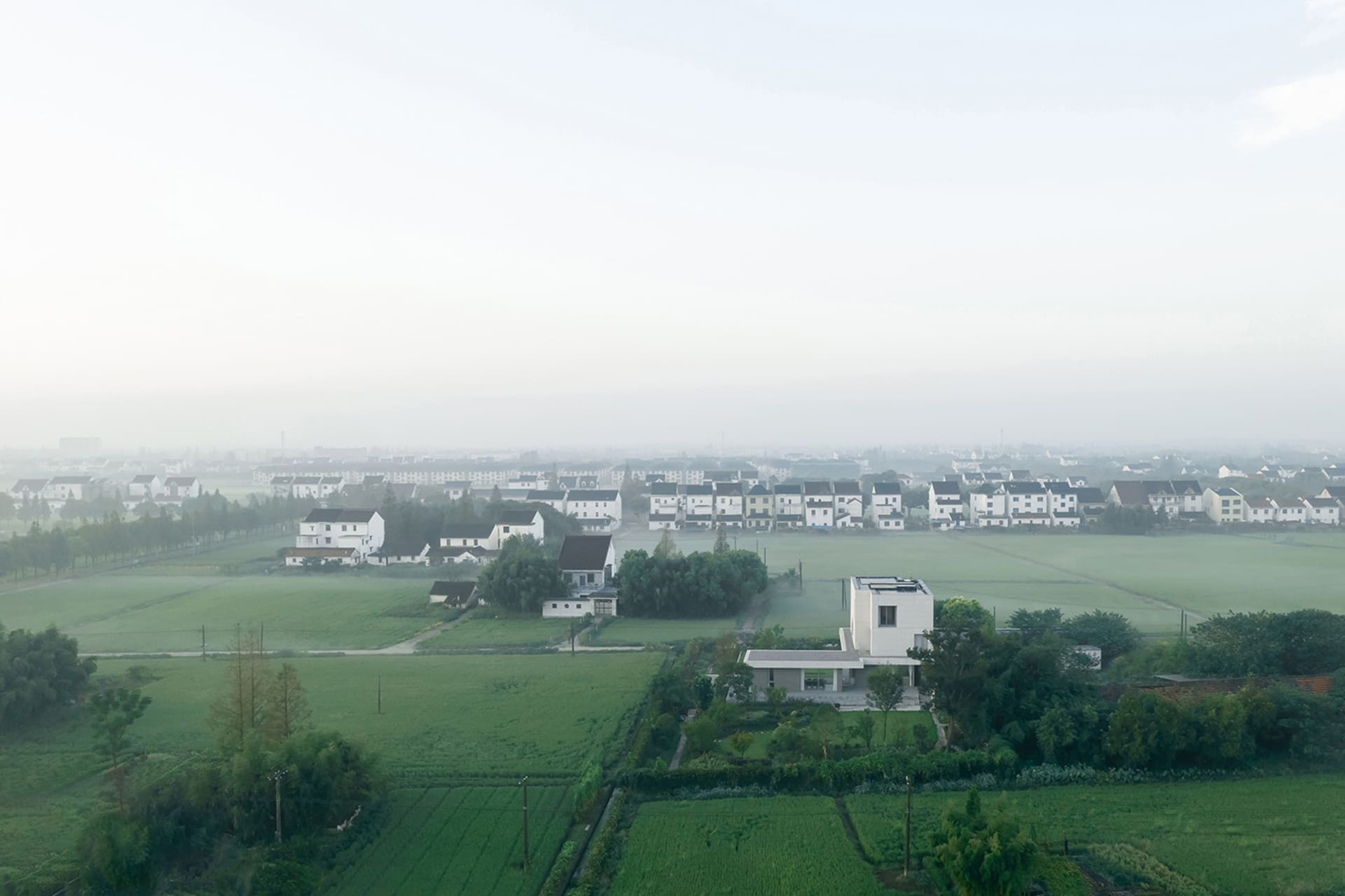 A aerial view of a urban landscape with buildings and green fields.