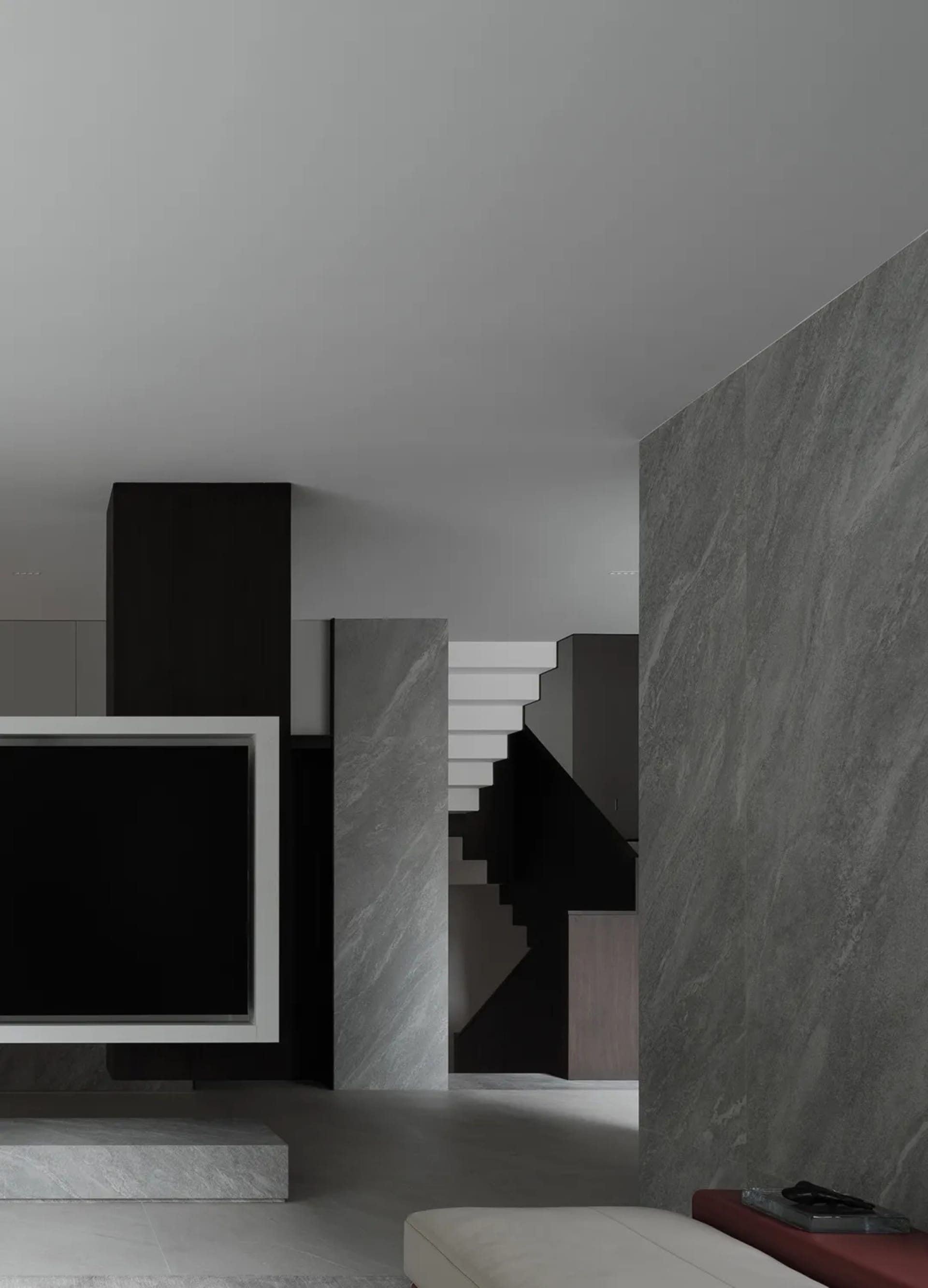 Modern interior design featuring a floating staircase with dark metallic elements in a living room setting.