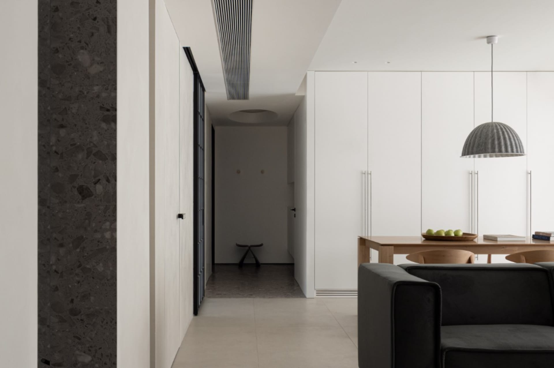 A modern living room with concrete flooring and minimalist furniture.