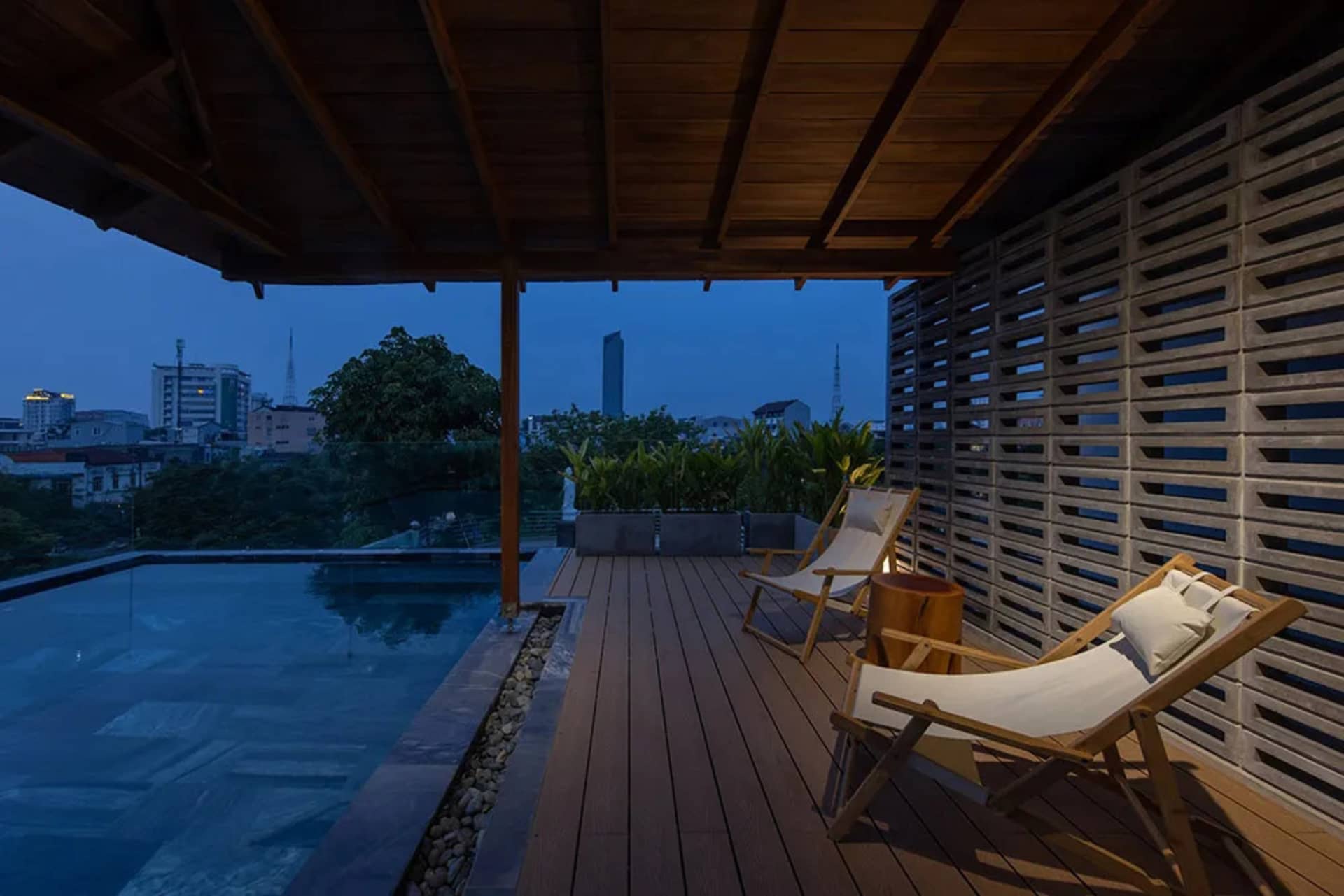 Modern residential patio featuring glass walls and a wooden deck.