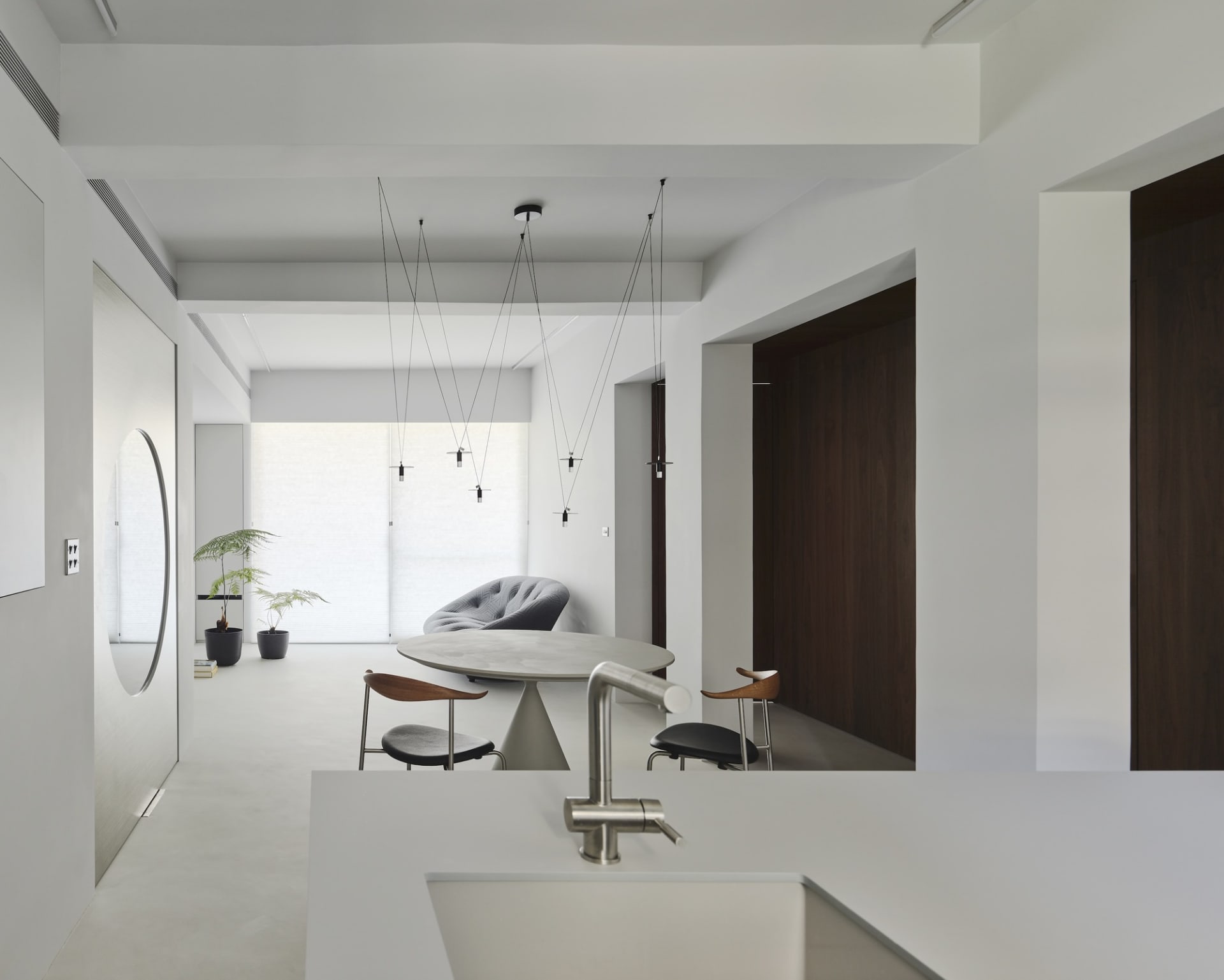 A modern residential kitchen featuring a concrete countertop and minimalist design elements.
