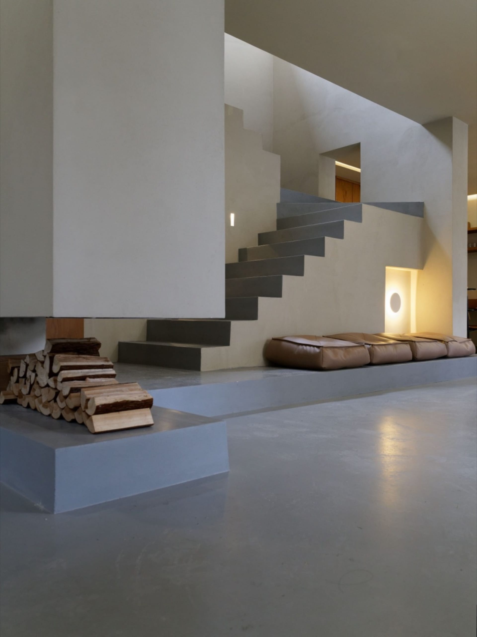 Modern residential lounge featuring concrete and leather elements.