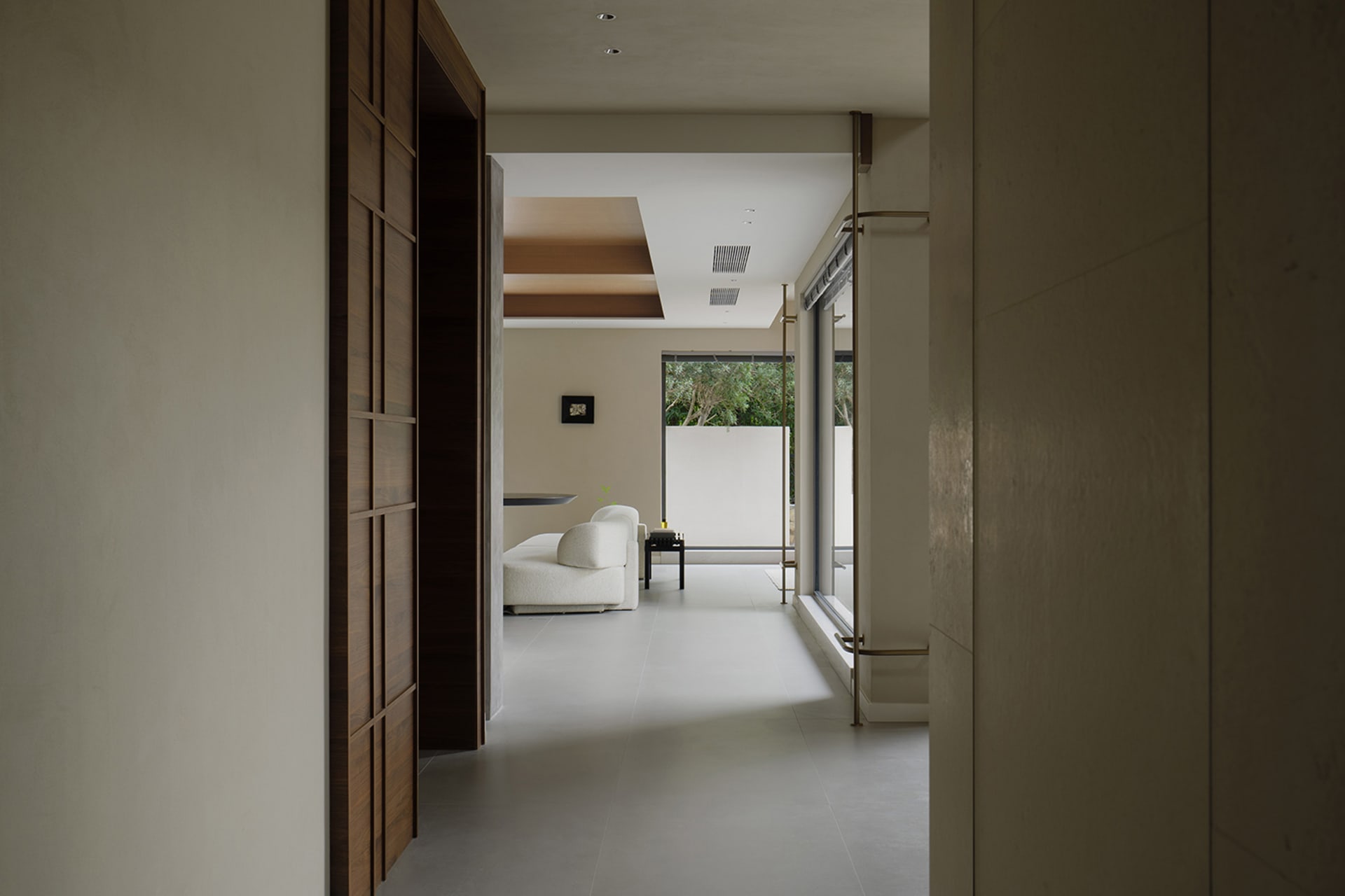 A minimalist living room featuring concrete walls and floor.