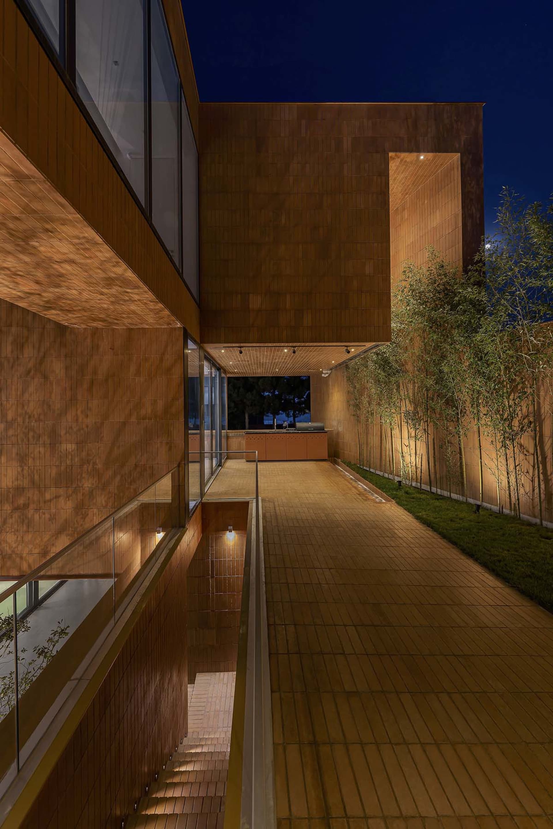 Modern house exterior featuring a board finish with wooden siding and green hedges.