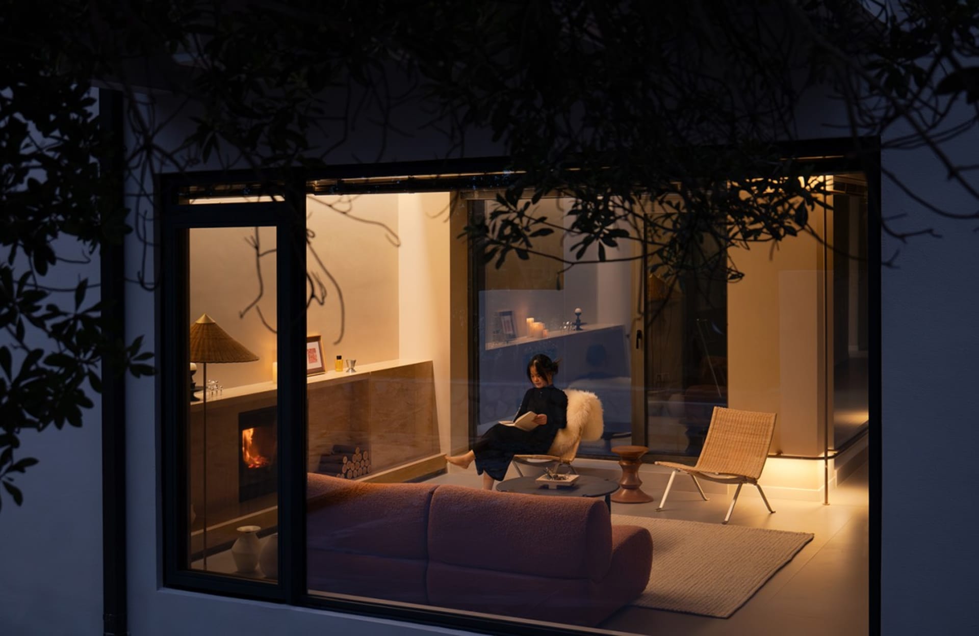 A cozy, modern residential interior with a warm, inviting ambiance, featuring a comfortable seating area, a fireplace, and a