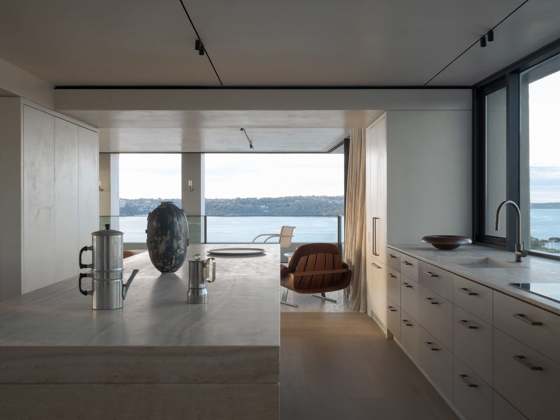 Modern kitchen with concrete countertops and a view of the water.