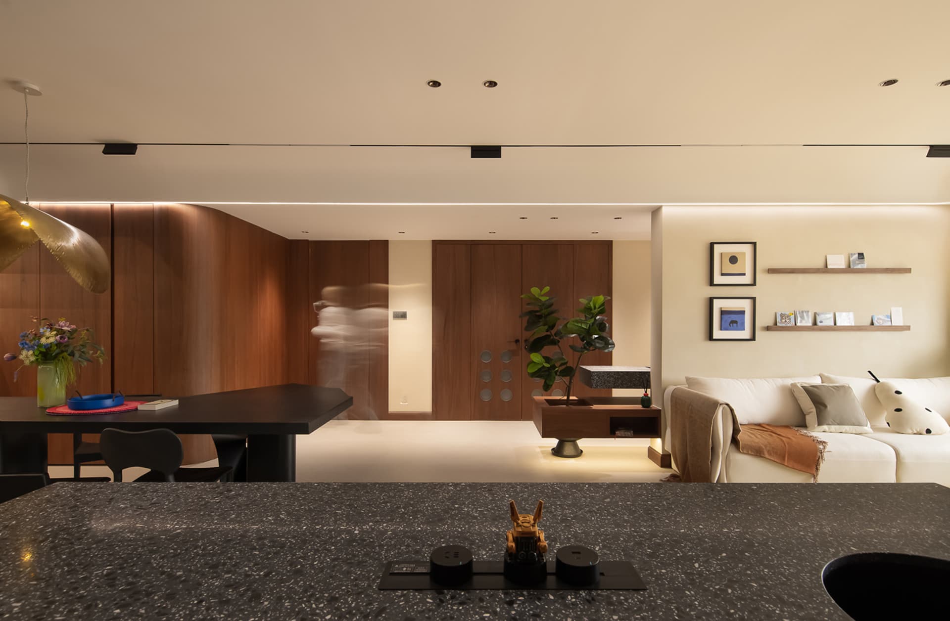 Modern living room featuring black furniture, a white sofa, and a terrazzo countertop.