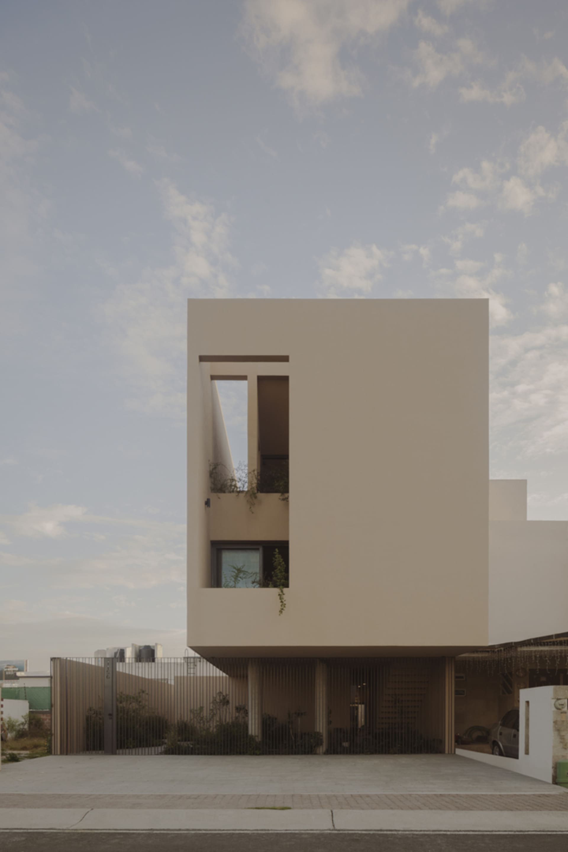 A minimalist modern house featuring a concrete exterior and large windows.