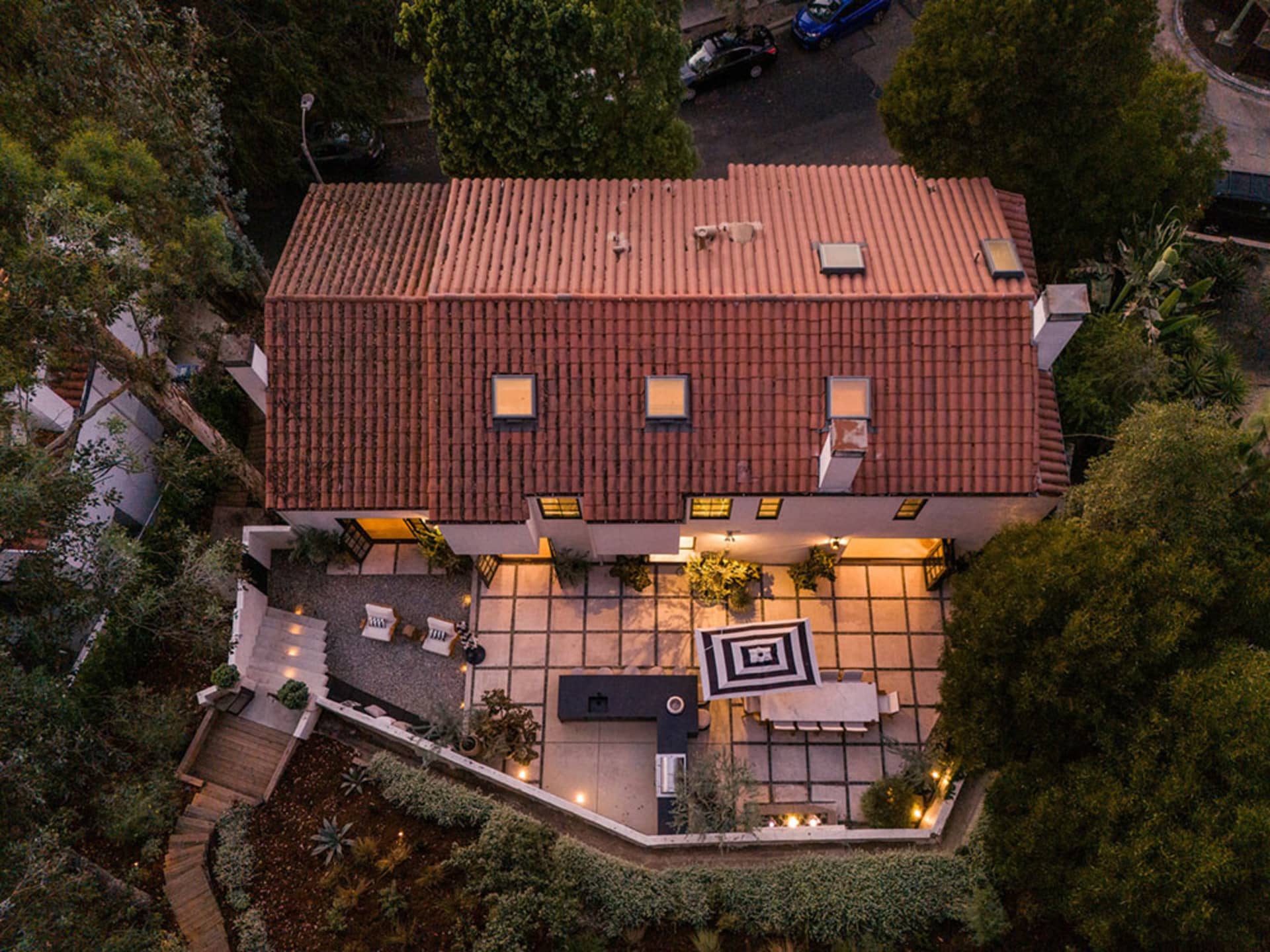 Aerial view of a residential home with a red terracotta roof and outdoor patio area.