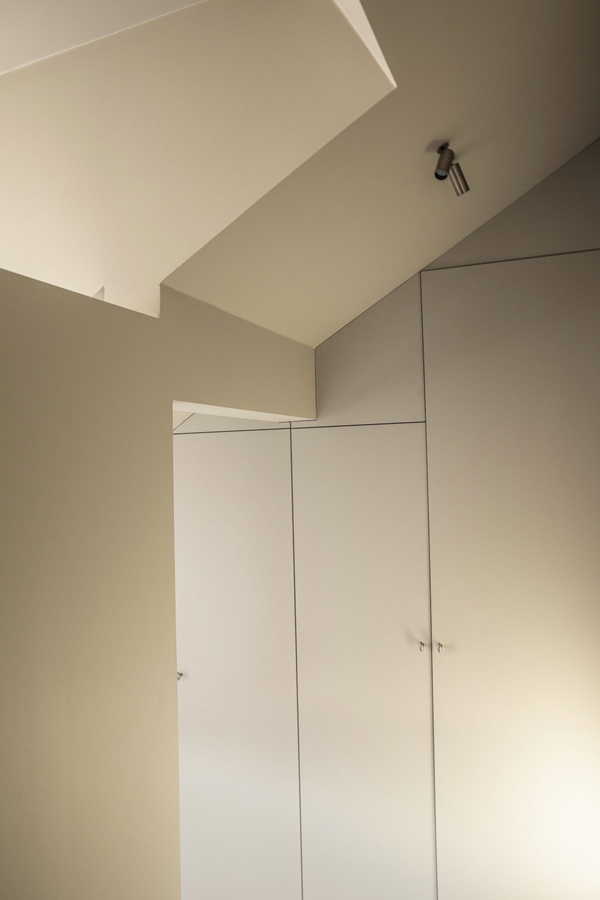 Modern minimalist closet with white cabinets and sleek design