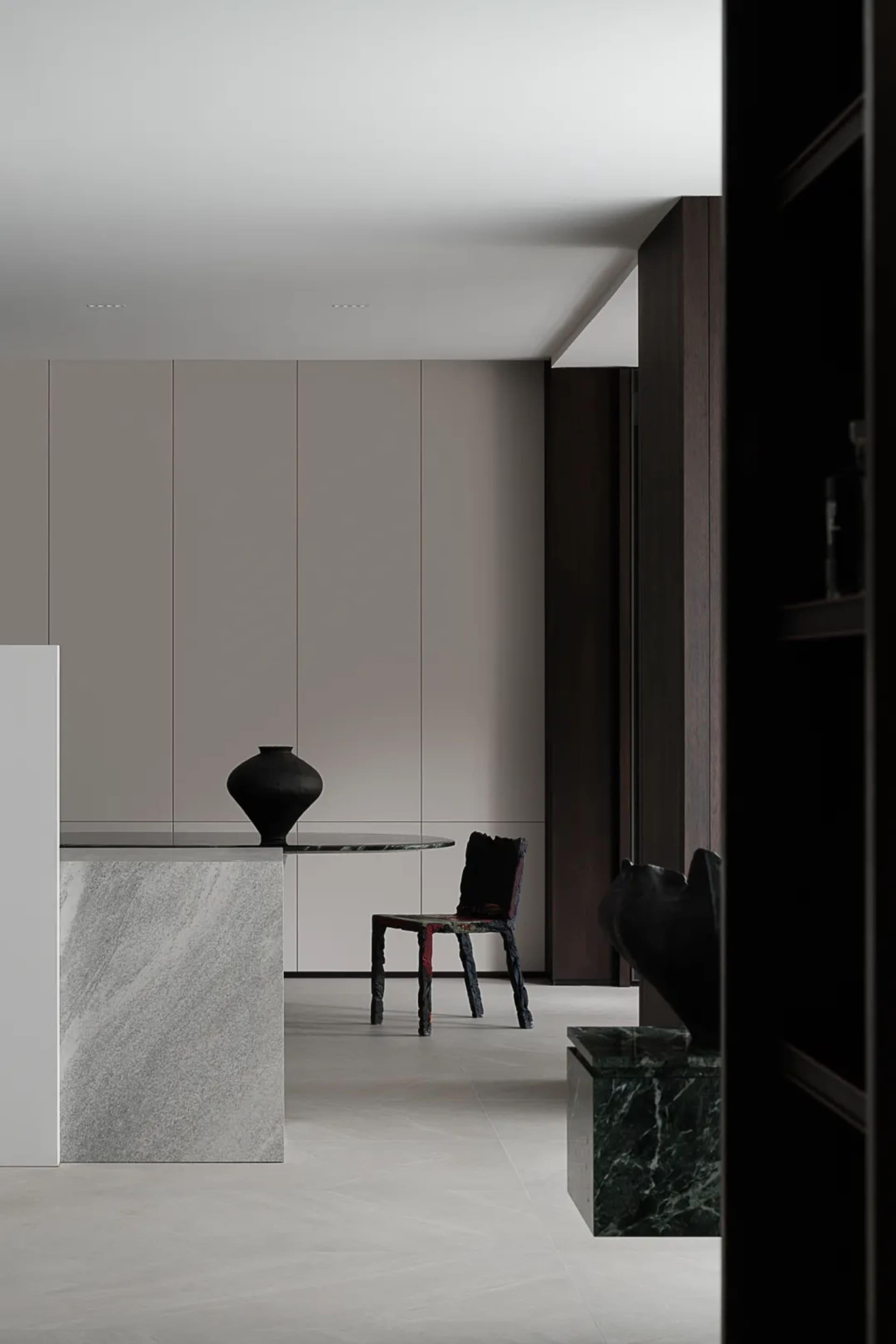 Minimalist modern interior space featuring marble surfaces and geometric seating.