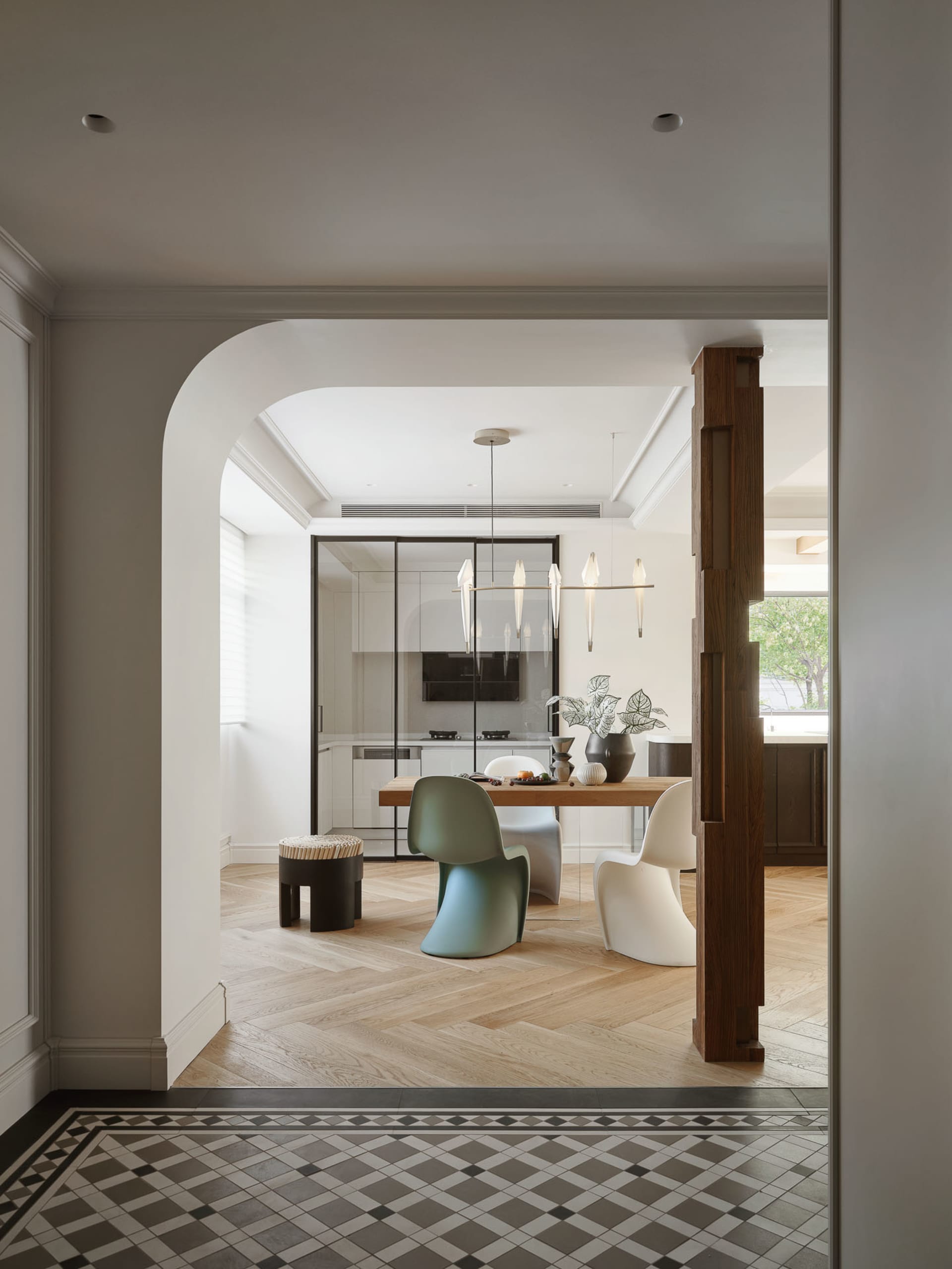 Modern minimalist residential kitchen with wooden table, glass pendant lights, and minimalist furniture.