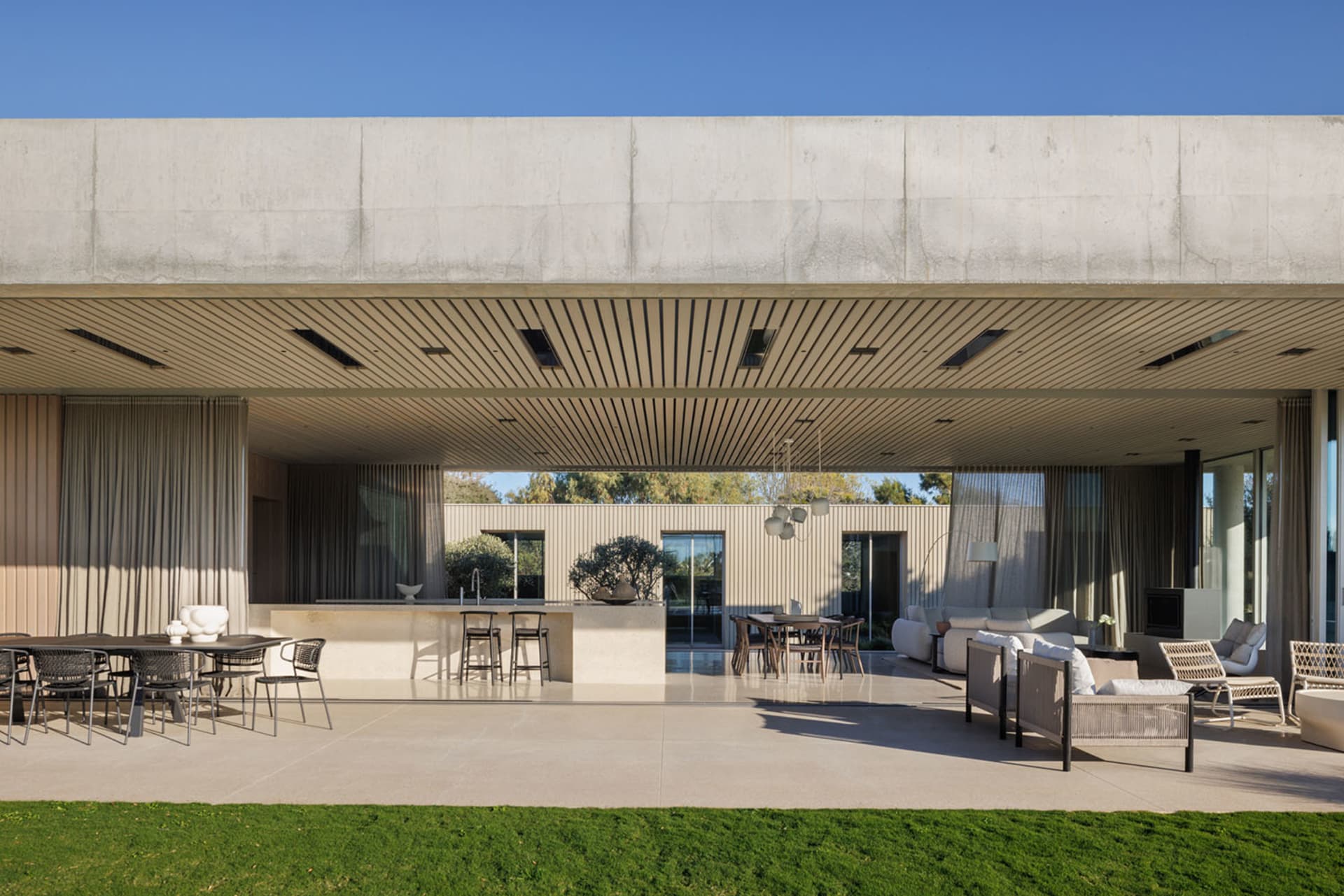 A modern residential patio featuring polished concrete flooring and natural stone accents.