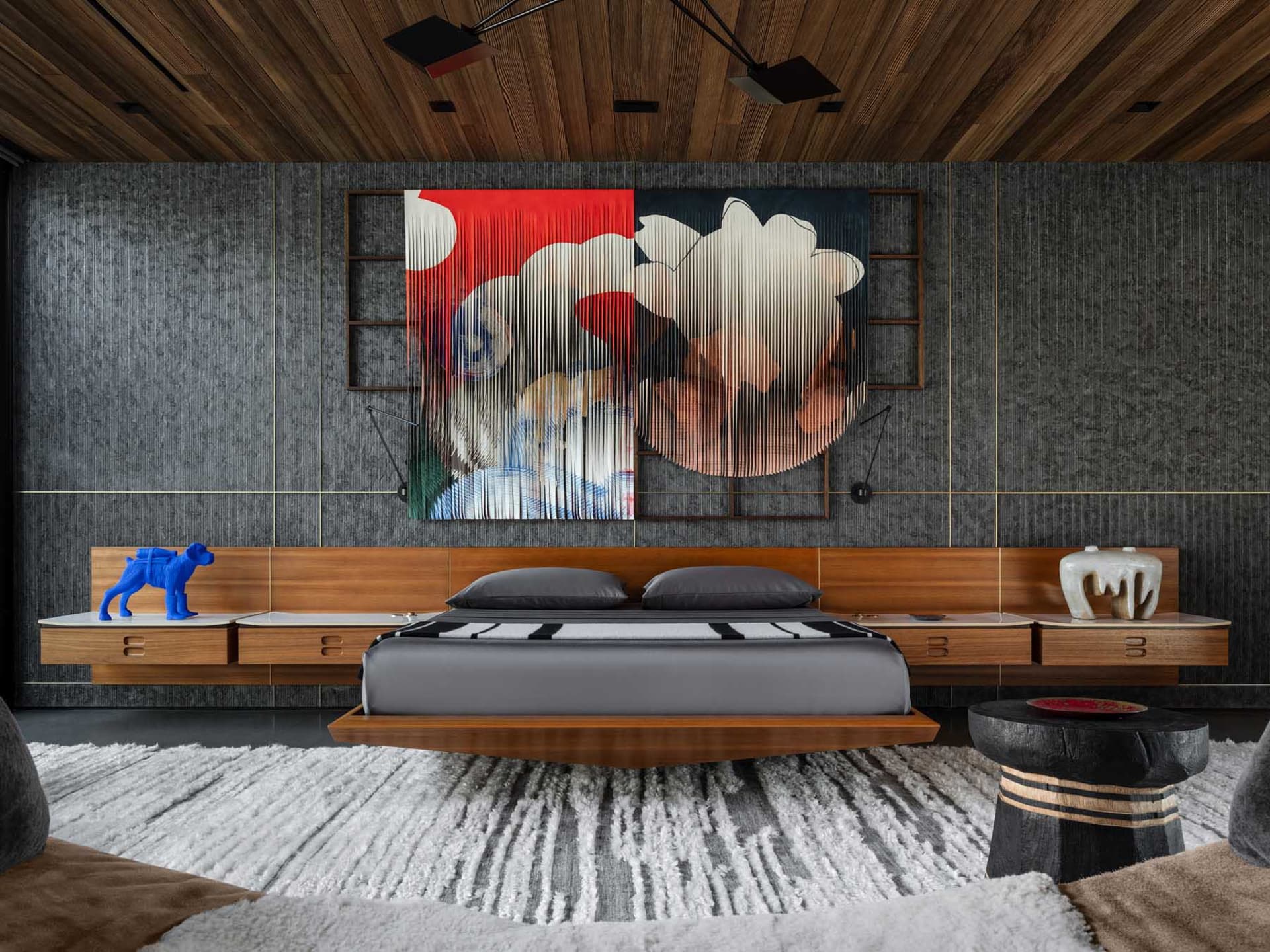 Industrial-themed bedroom featuring a floating bed with wooden accents and a bold, abstract wall art piece on the dark wall.