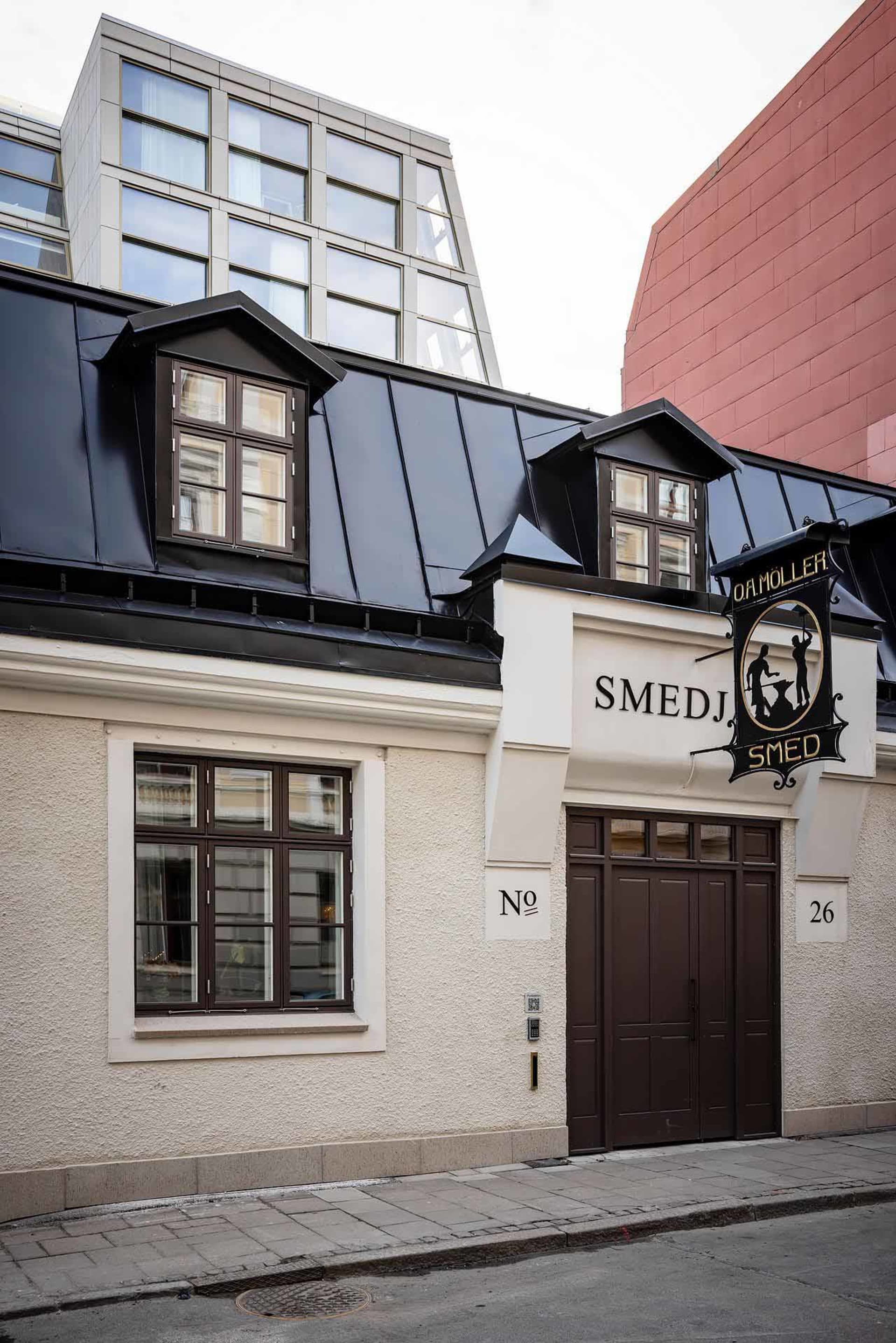 Modern storefront with white exterior, dark roof, and large windows.