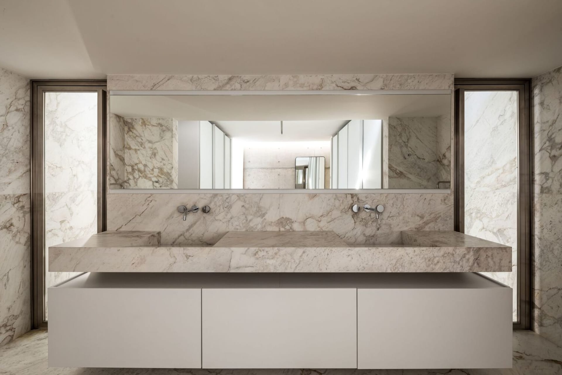 Modern bathroom featuring marble countertops and walls