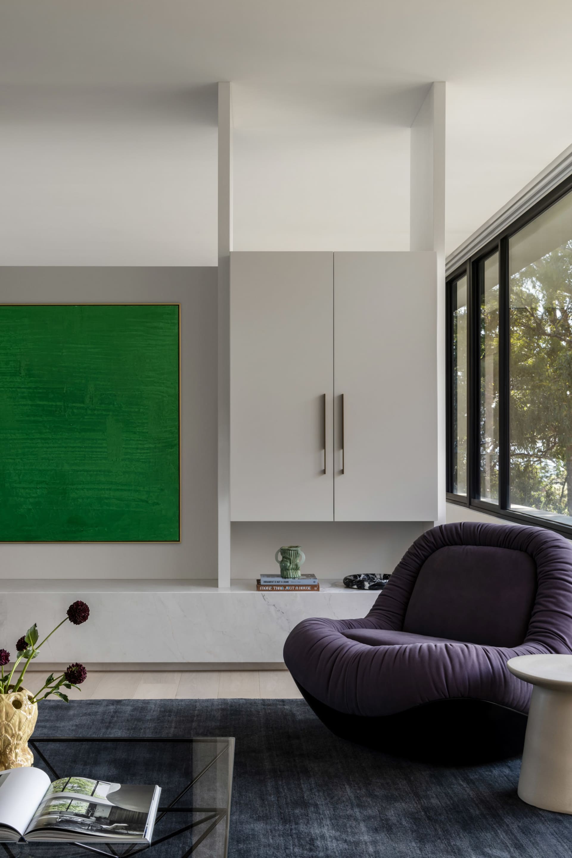 Modern minimalist living room featuring marble, glass, and metal accents.