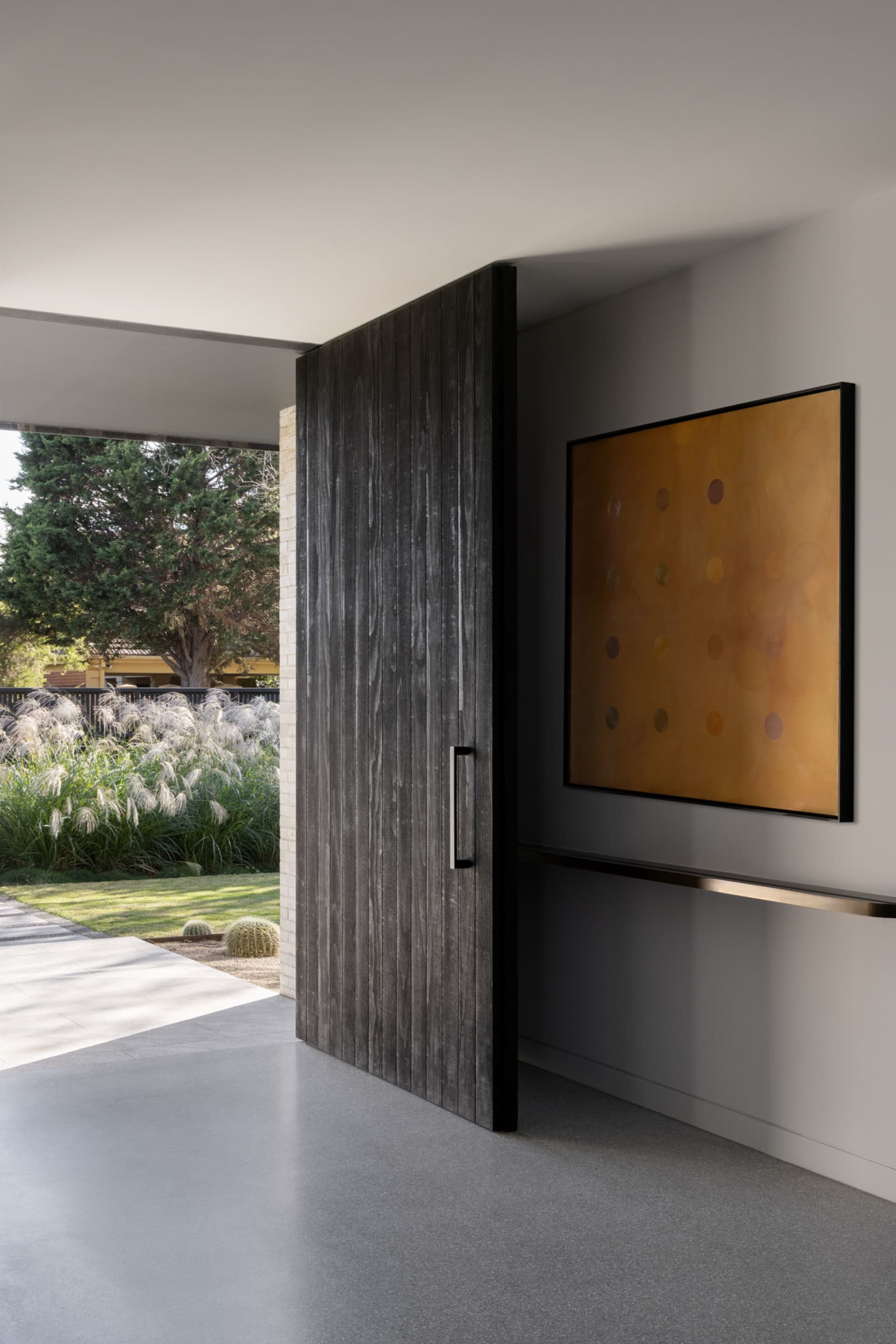 Modern industrial-style front door with a concrete base and wooden paneling in a residential entrance.