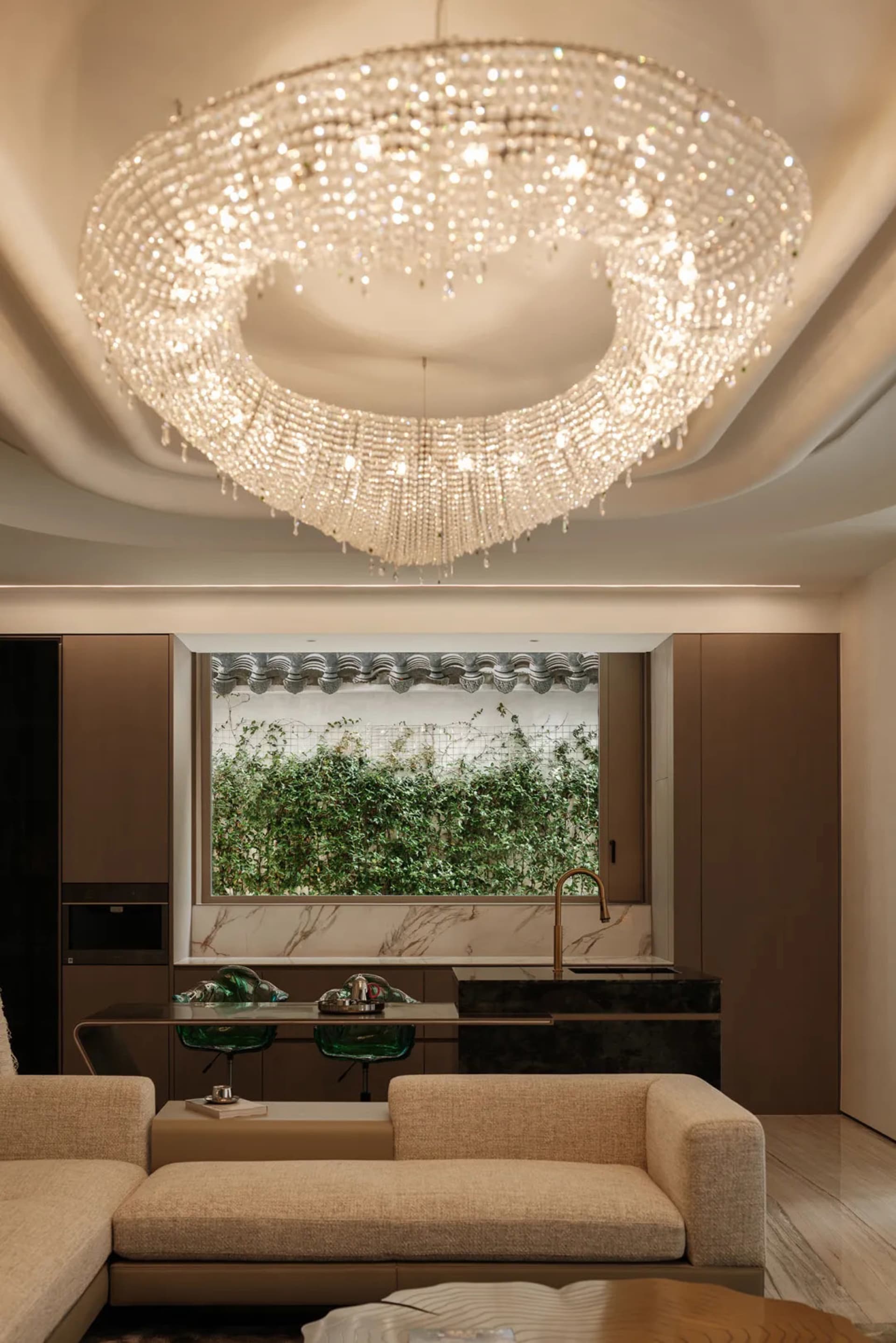 A modern living room featuring a metal chandelier hanging from the ceiling.