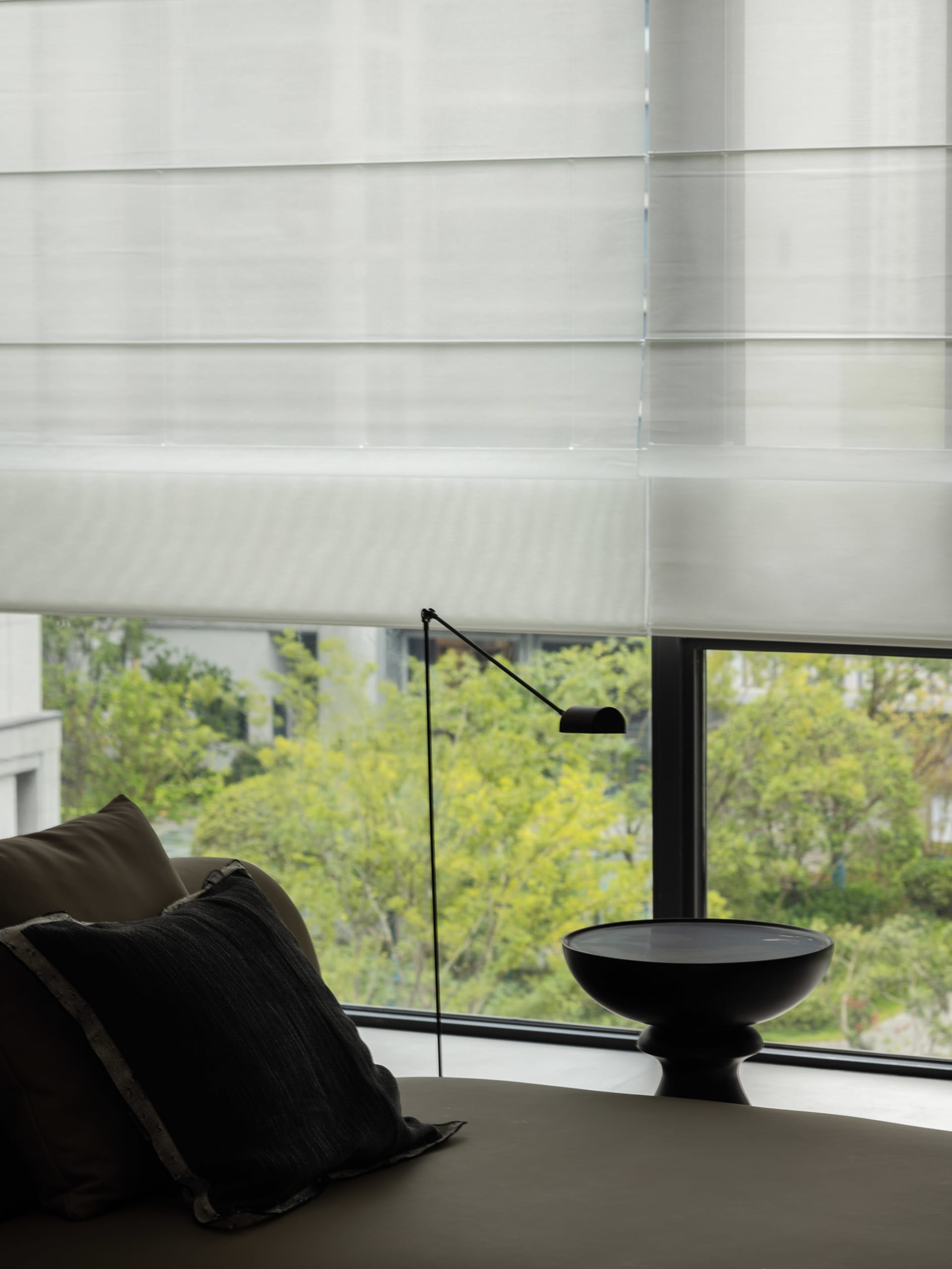 A modern living space featuring luxurious fabric blinds and minimalist decor.